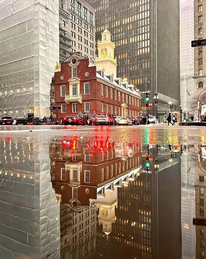 Old State House in Boston, Massachusetts, reflected in a puddle on a wet street By Nick Kosturos