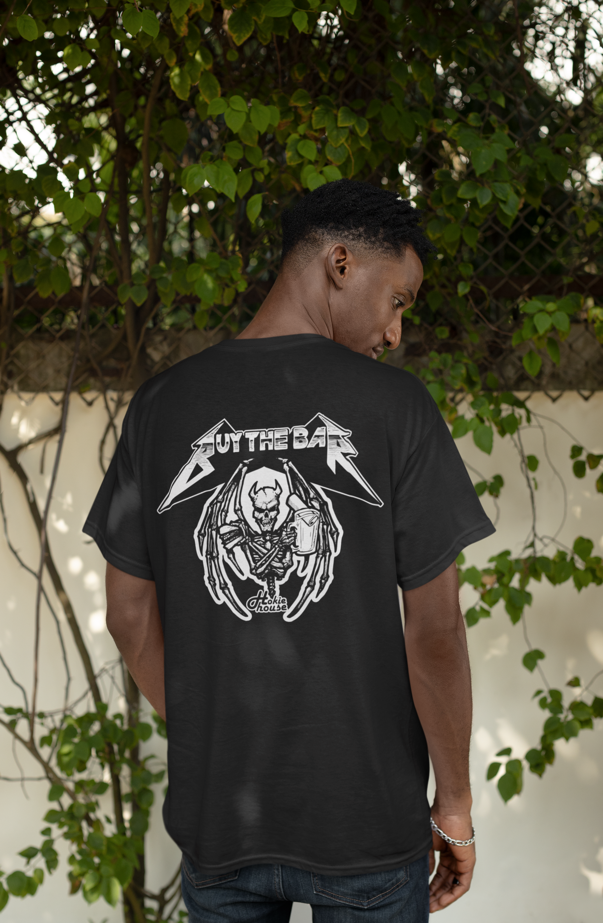 back-view-t-shirt-mockup-featuring-a-man-posing-against-a-wall-with-plants-m37880.png