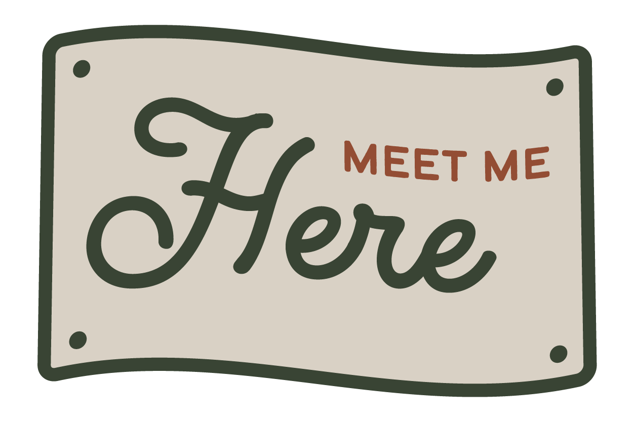 Sign with the words 'Meet Me Here' in stylized text.