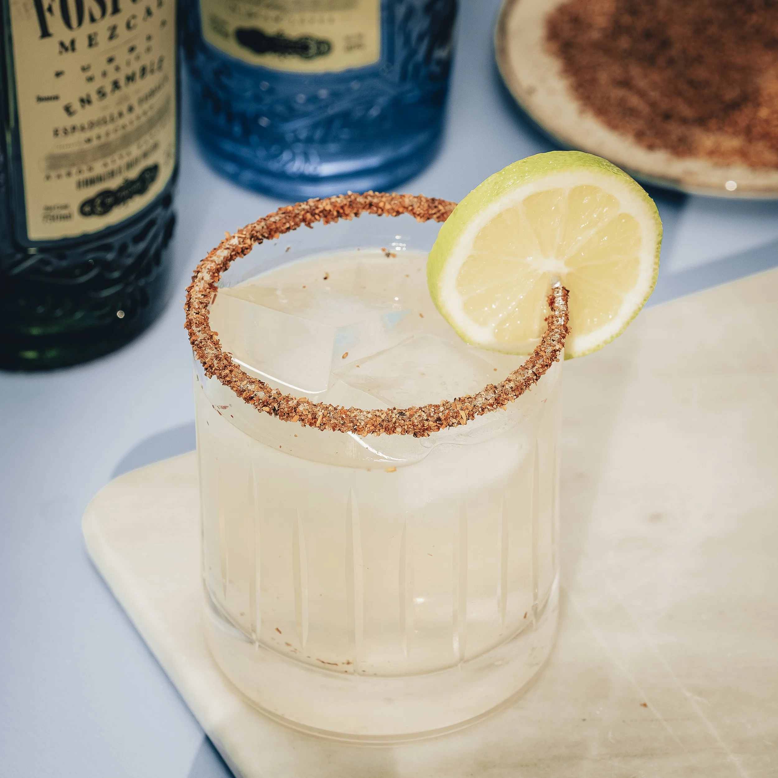 Margarita with tequila, citrus, and chili-salt rim served over ice with lime garnish