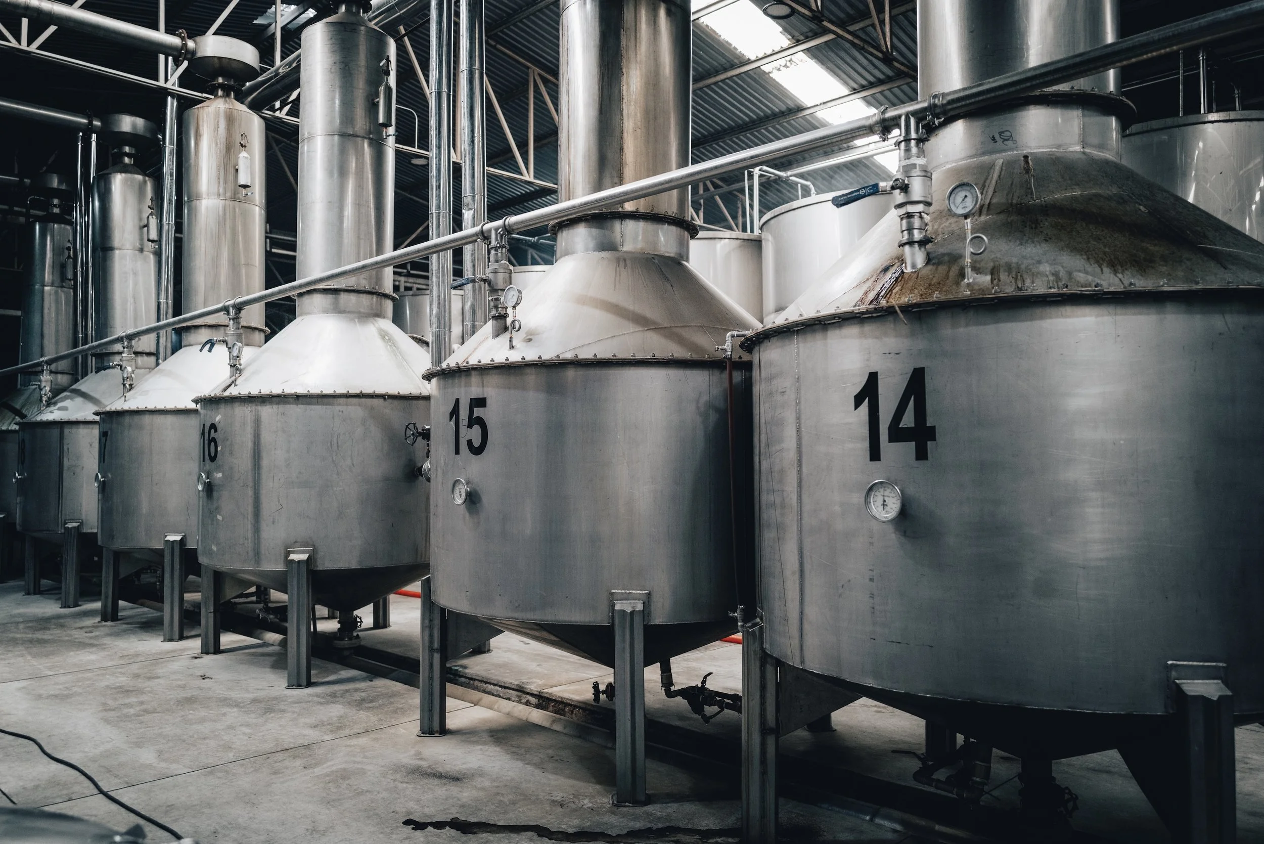 Industrial tanks with pressure gauges in a brewery or factory setting.