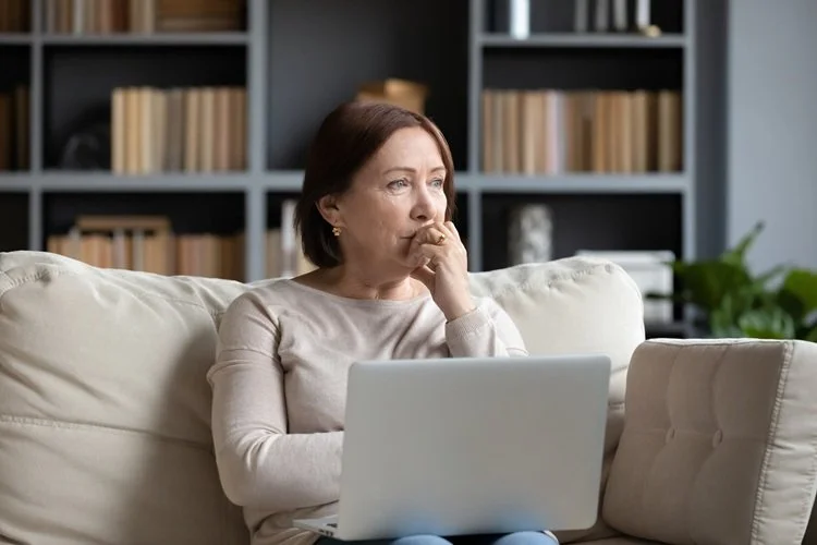 A middle-aged woman sitting with a laptop computer
