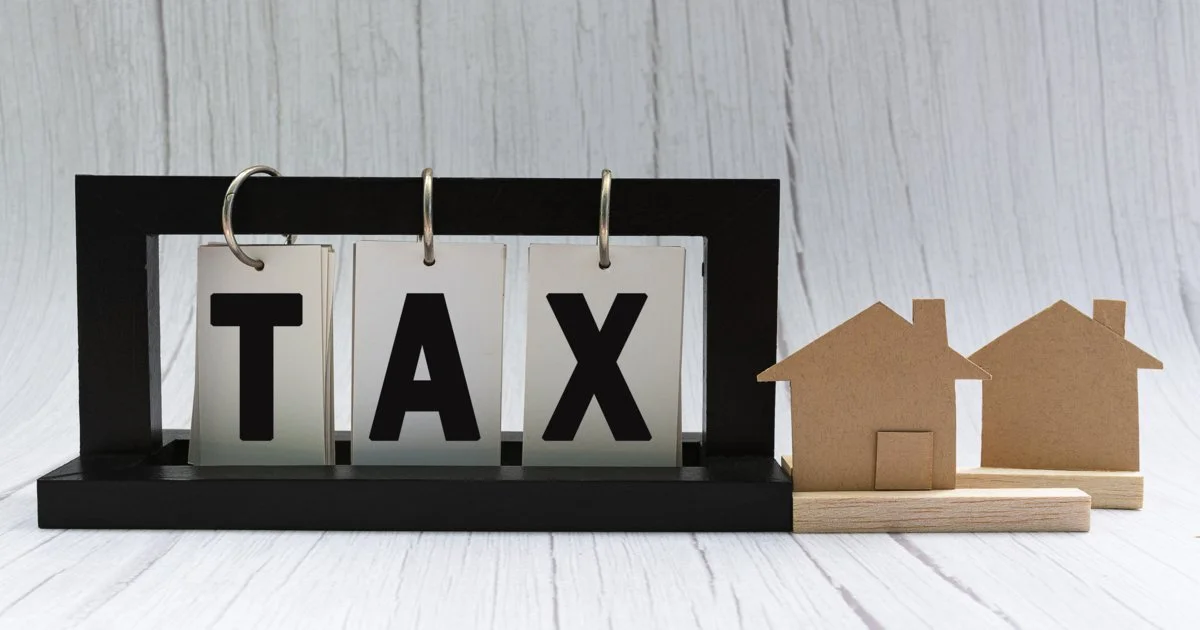 tax-text-on-paper-stand-black-frame-with-house-model