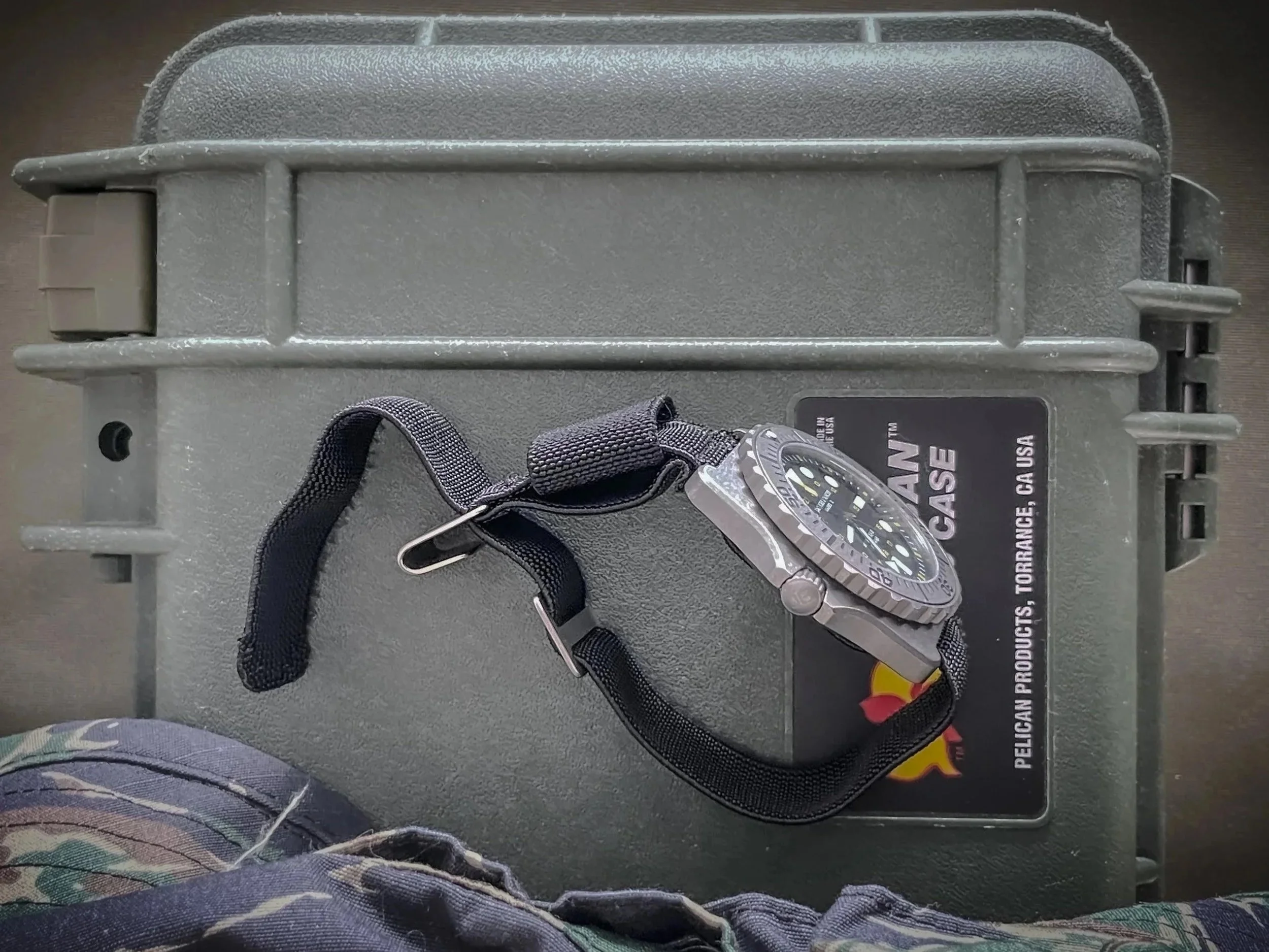 Aquaborne System-21 Riser watch strap in black fitted to a black dive watch on a Pelican case surface