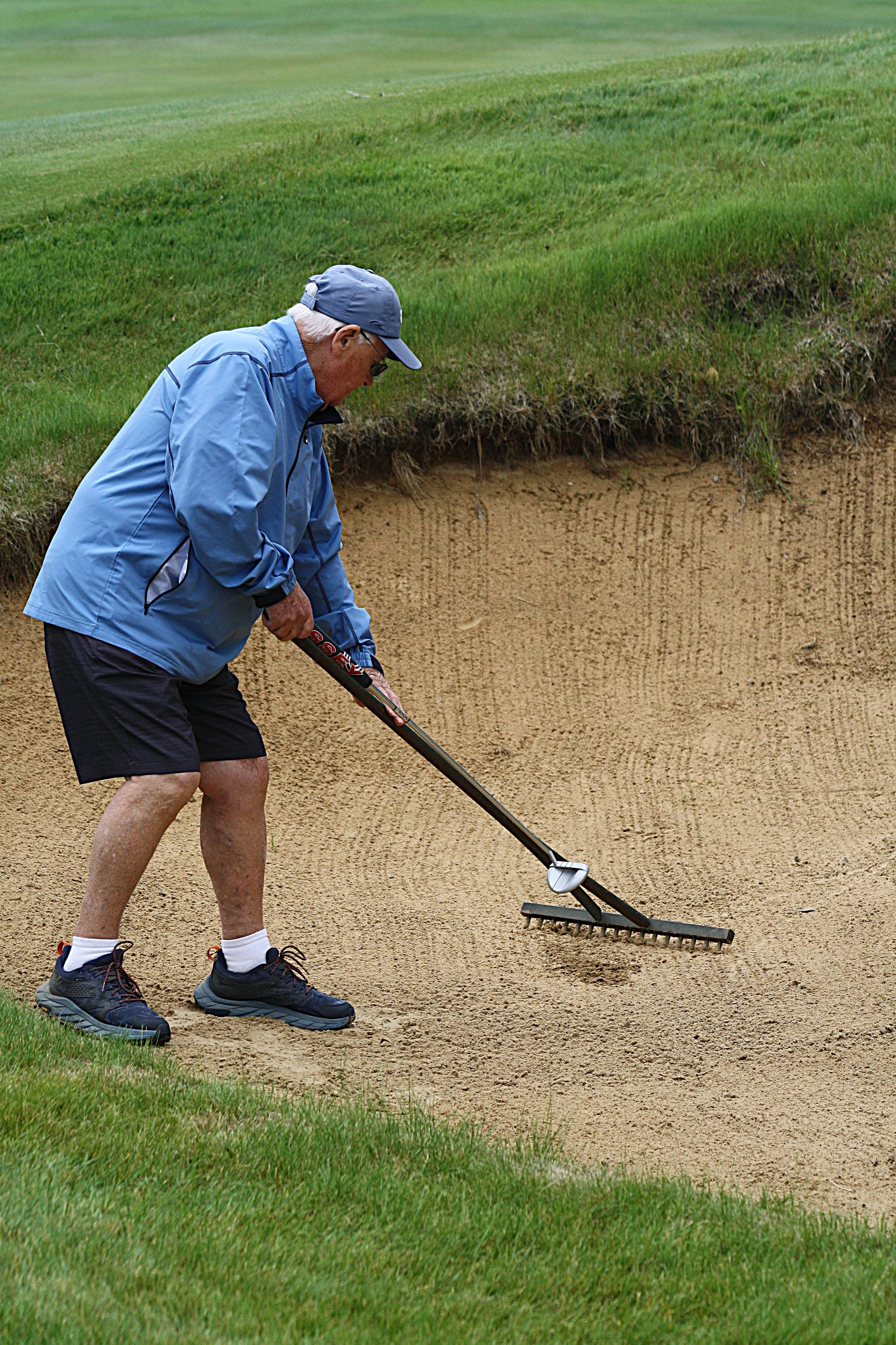 Caddie Joe raking bunker.JPG