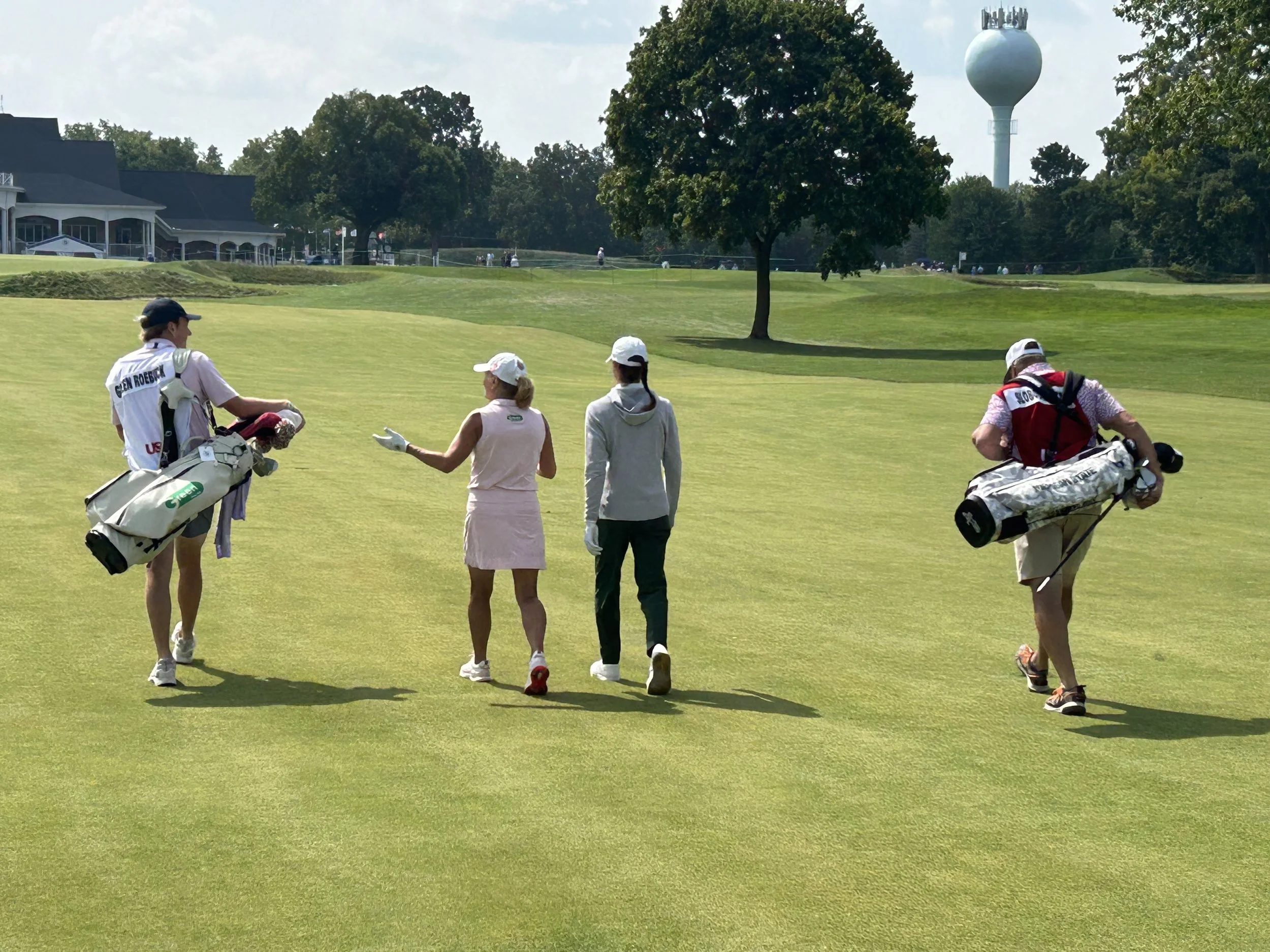 Suzy and Stacy and caddies in 18 fairway.jpg