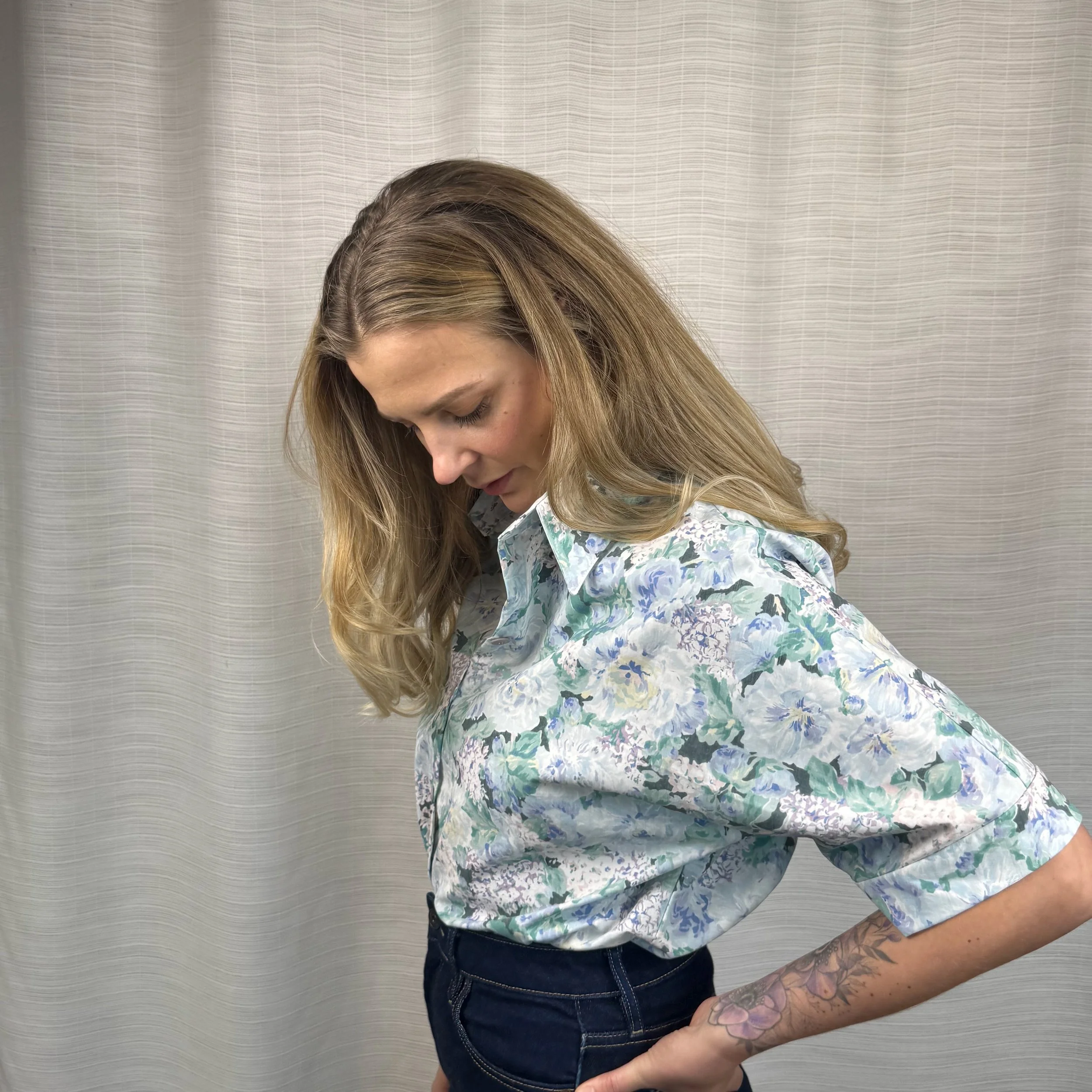 Woman wearing oversized blue floral batwing shirt handmade from vintage bedsheet, size Small
