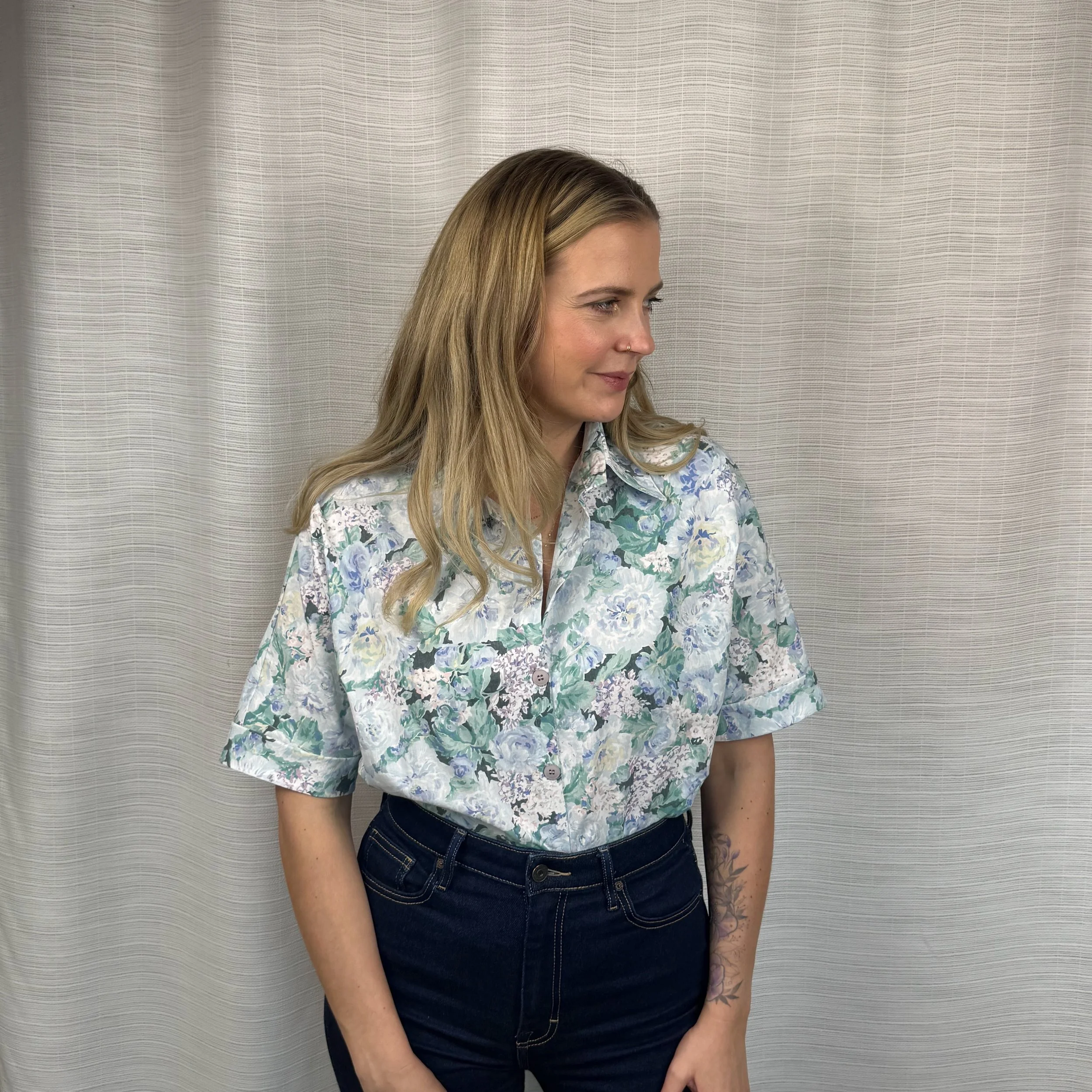 Woman wearing oversized blue floral batwing shirt handmade from vintage bedsheet, size Small