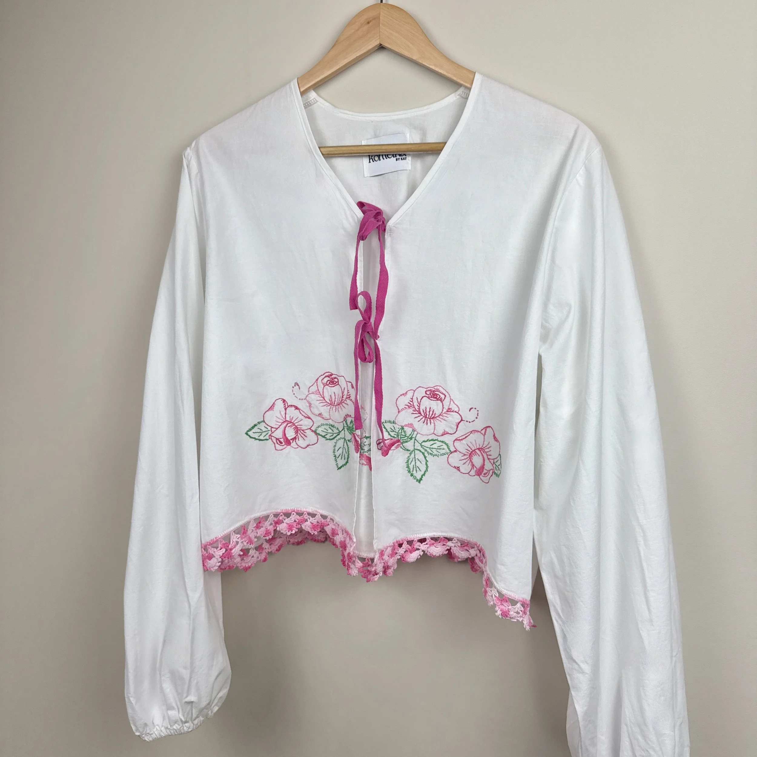 White embroidered blouse upcycled from vintage bedsheet with pink floral details and crochet trim