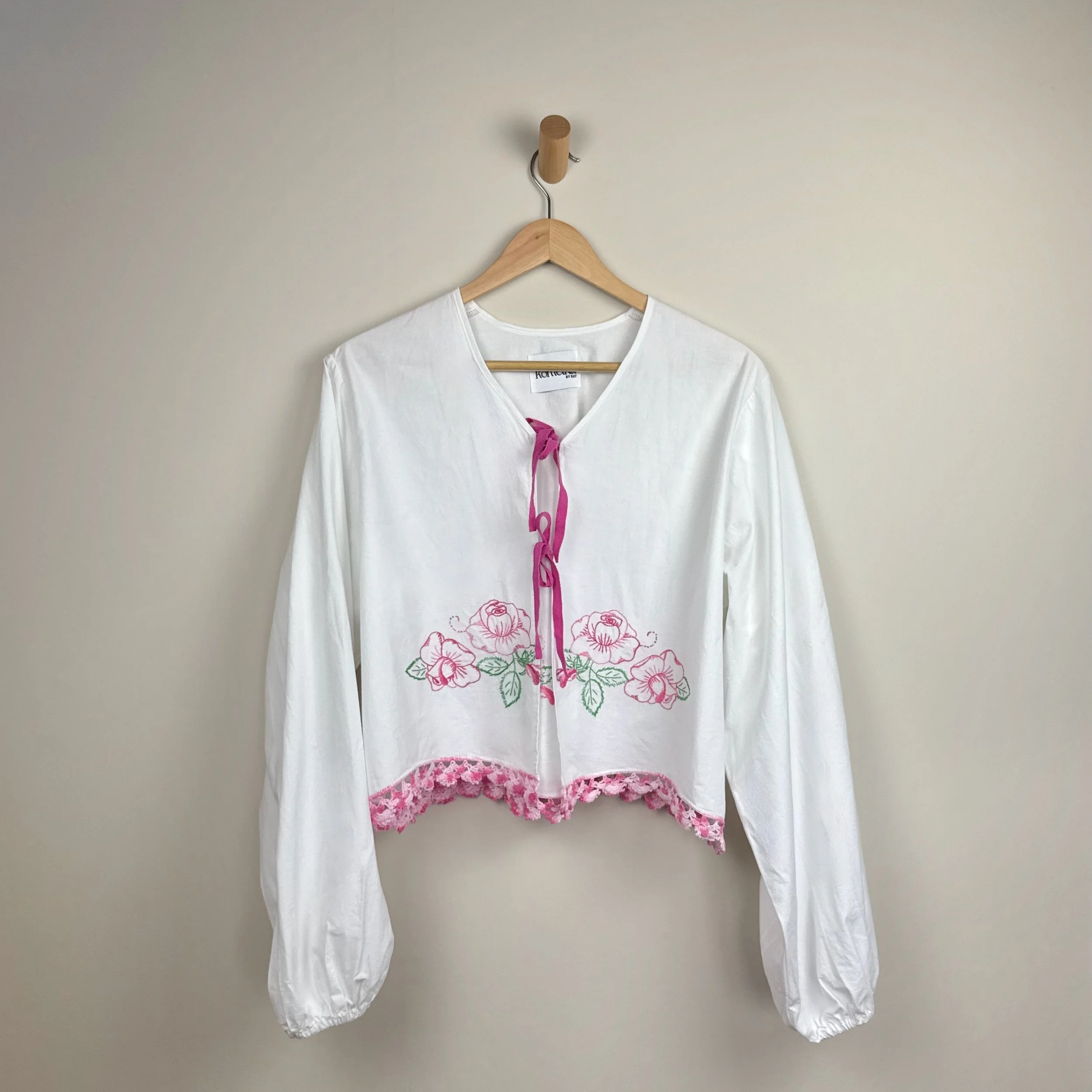 White embroidered blouse upcycled from vintage bedsheet with pink floral details and crochet trim