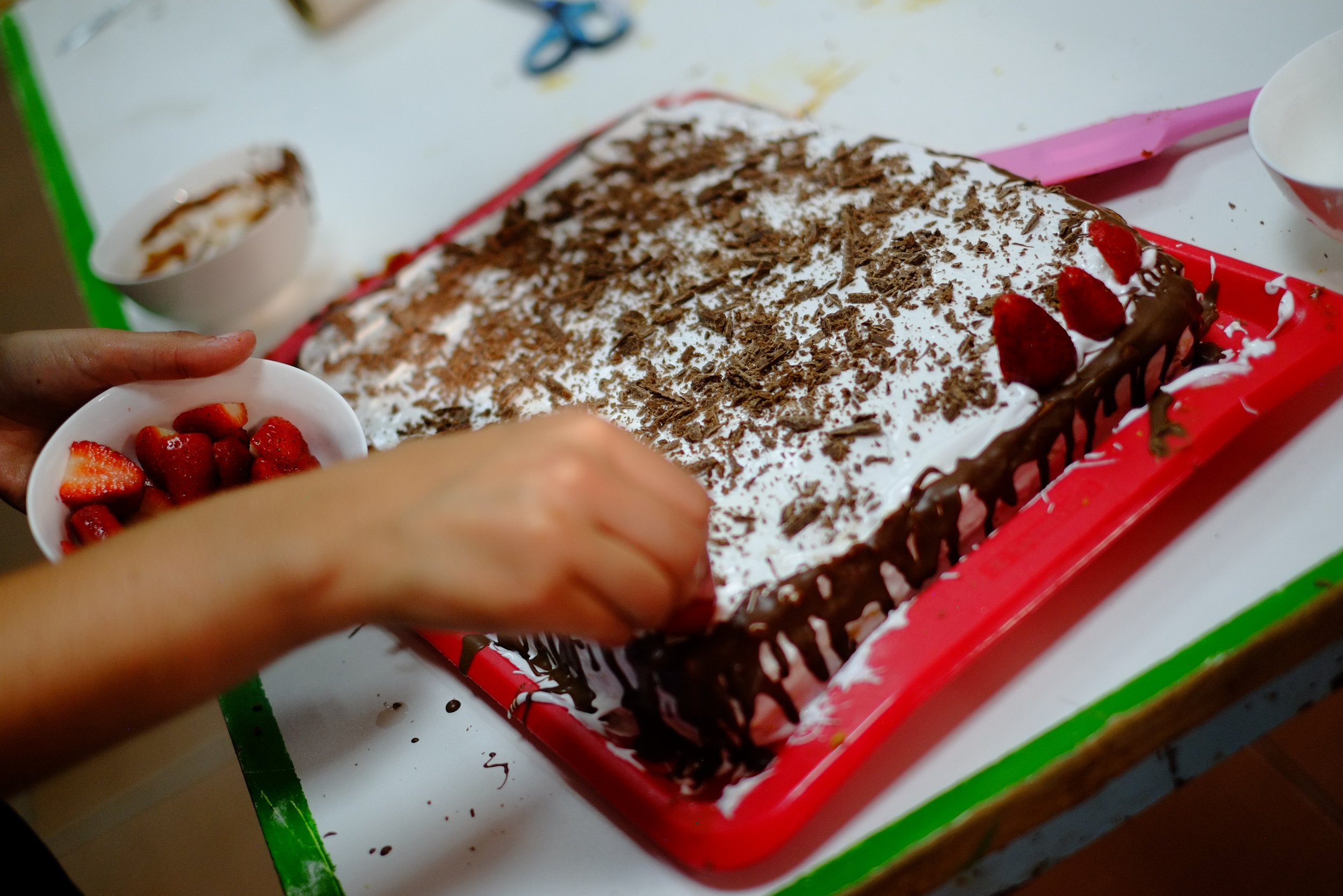 The birthday cake getting decorated