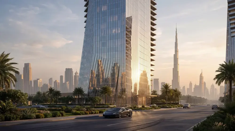Modern glass skyscraper reflecting surrounding buildings and palm trees, with the Dubai skyline and Burj Khalifa in the background during sunset.