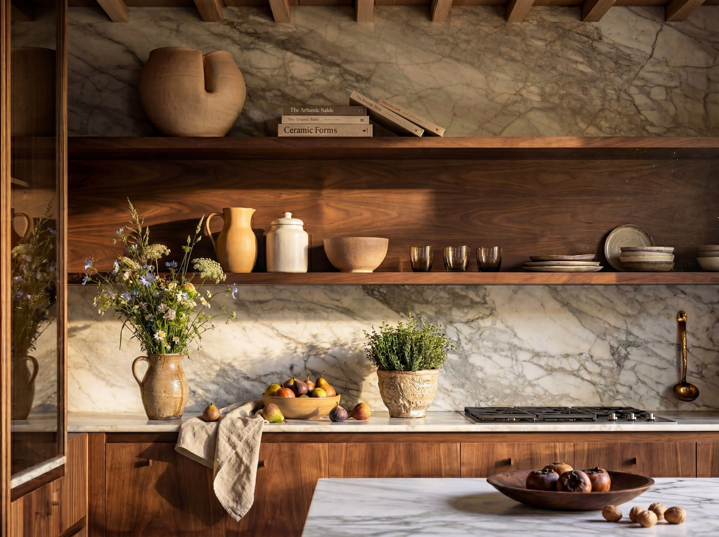 A kitchen with open wooden shelves and a marble backsplash, decorated with bowls, vases, books, and plants, with fruits on the marble countertop.