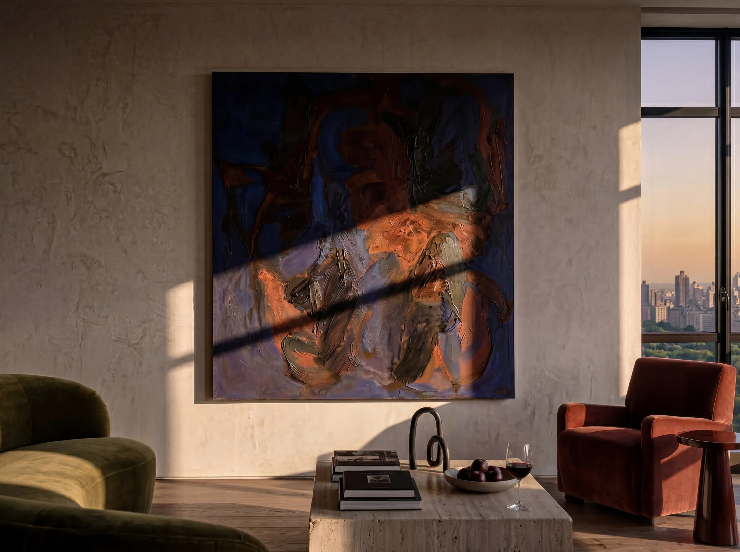 Interior of a modern apartment living room with a large abstract painting on a beige wall, a green sofa, a pink velvet armchair, a wooden coffee table with books, a bowl of fruit, and a glass of red wine. Large window with cityscape view and sunset l