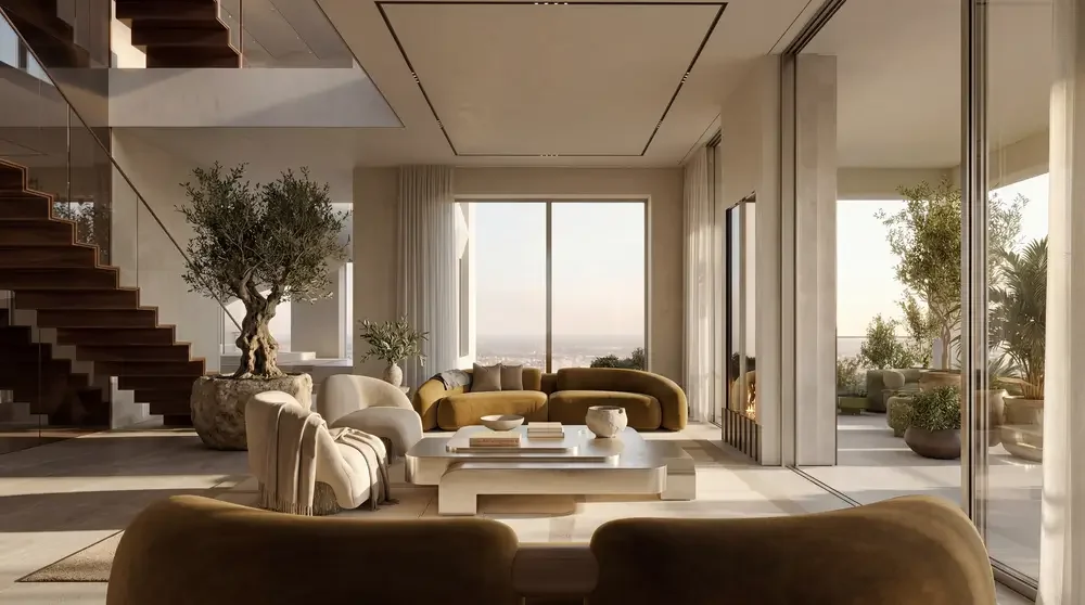 Modern living room with large windows, beige and mustard yellow sofas, a white coffee table, potted trees, and a staircase on the left.