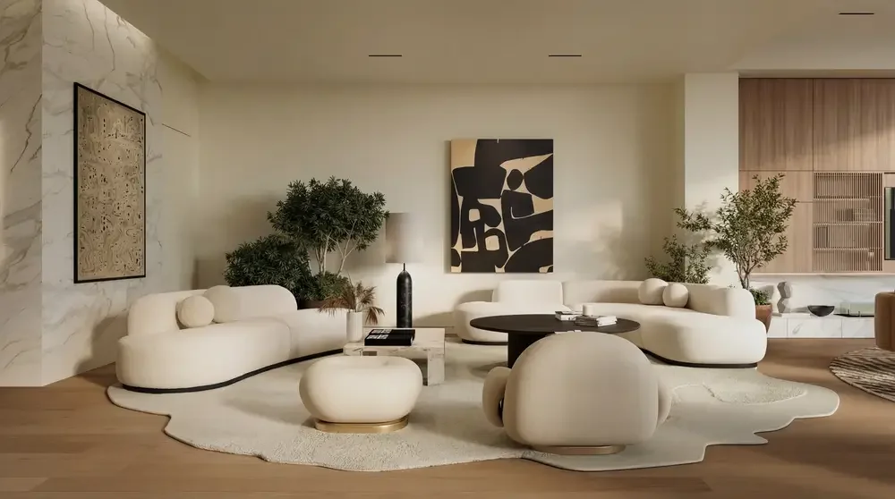 Modern living room with white curved sofa and armchair, abstract black and beige wall art, green potted plants, round coffee table, and minimal decor.