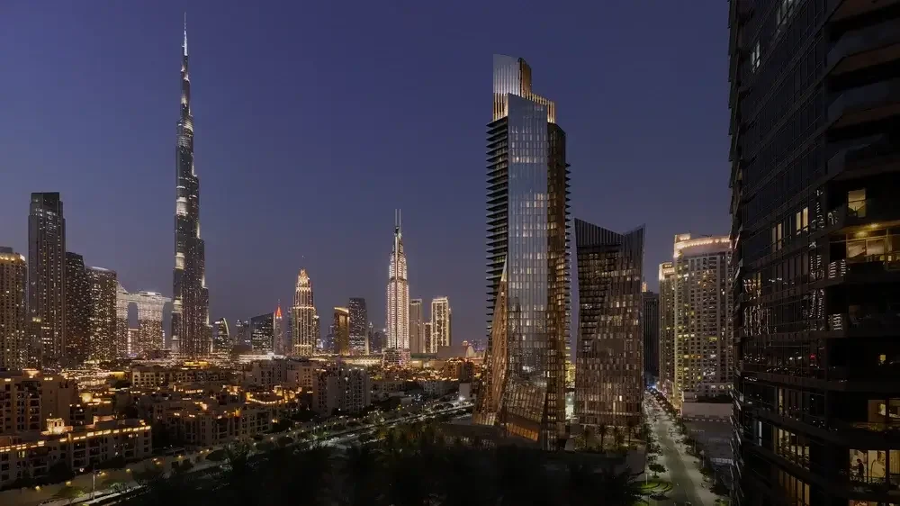 Nighttime cityscape of downtown Dubai, United Arab Emirates, featuring the Burj Khalifa and modern skyscrapers in the background.