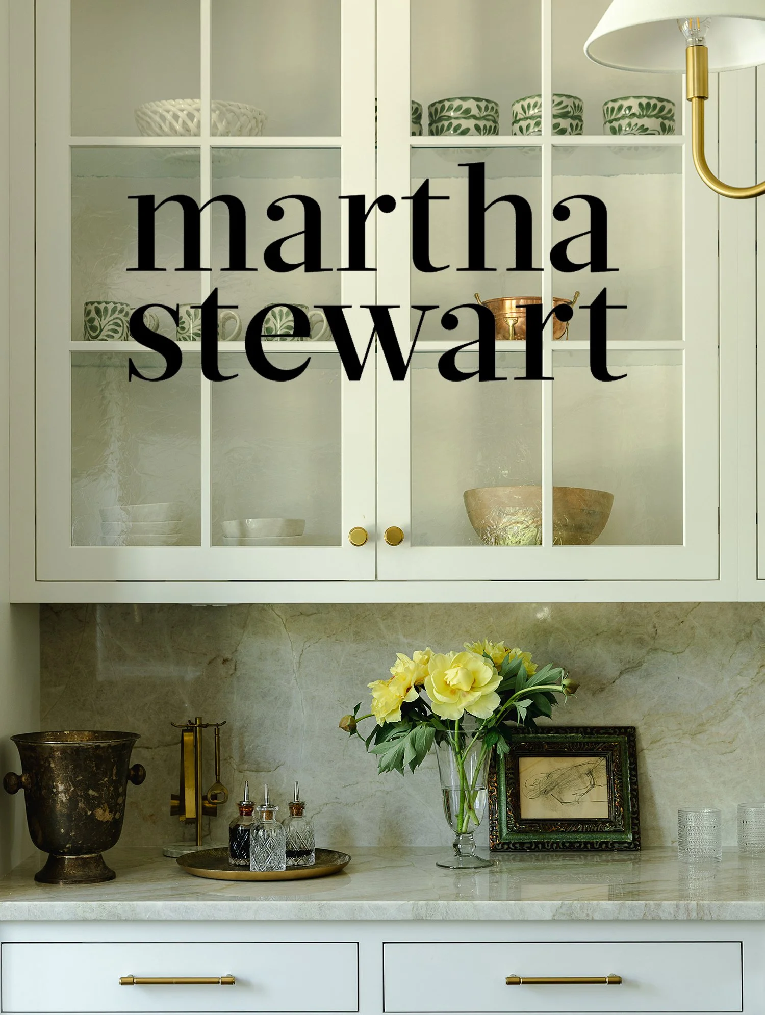 Martha Stewart article featuring Kate Kelly Interiors' expert advice on affordable kitchen upgrades, displayed over an elegant custom kitchen with glass-front cabinets, marble backsplash, and brass hardware.   