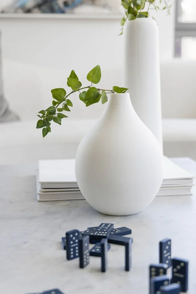 Hope Street | Family Room | Kate Kelly Interiors | Brooklyn, NY. Contemporary living room coffee table styled with minimalist white ceramic vases, fresh greenery, marble tabletop, and decorative dominoes, showcasing modern home décor, organic styling