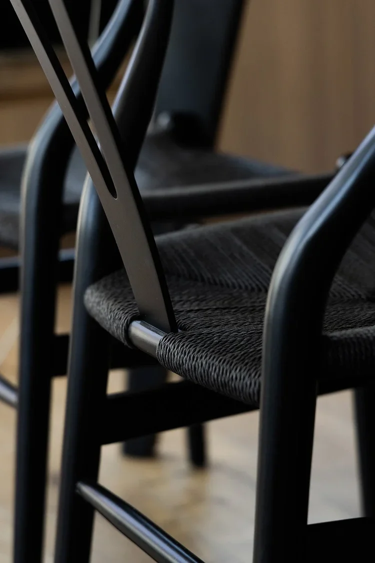 Hope Street | Dining Room | Kate Kelly Interiors | Brooklyn, NY. Close-up of modern black wishbone dining chairs with woven cord seats, showcasing handcrafted craftsmanship, clean Scandinavian-inspired lines, and contemporary furniture details in a l