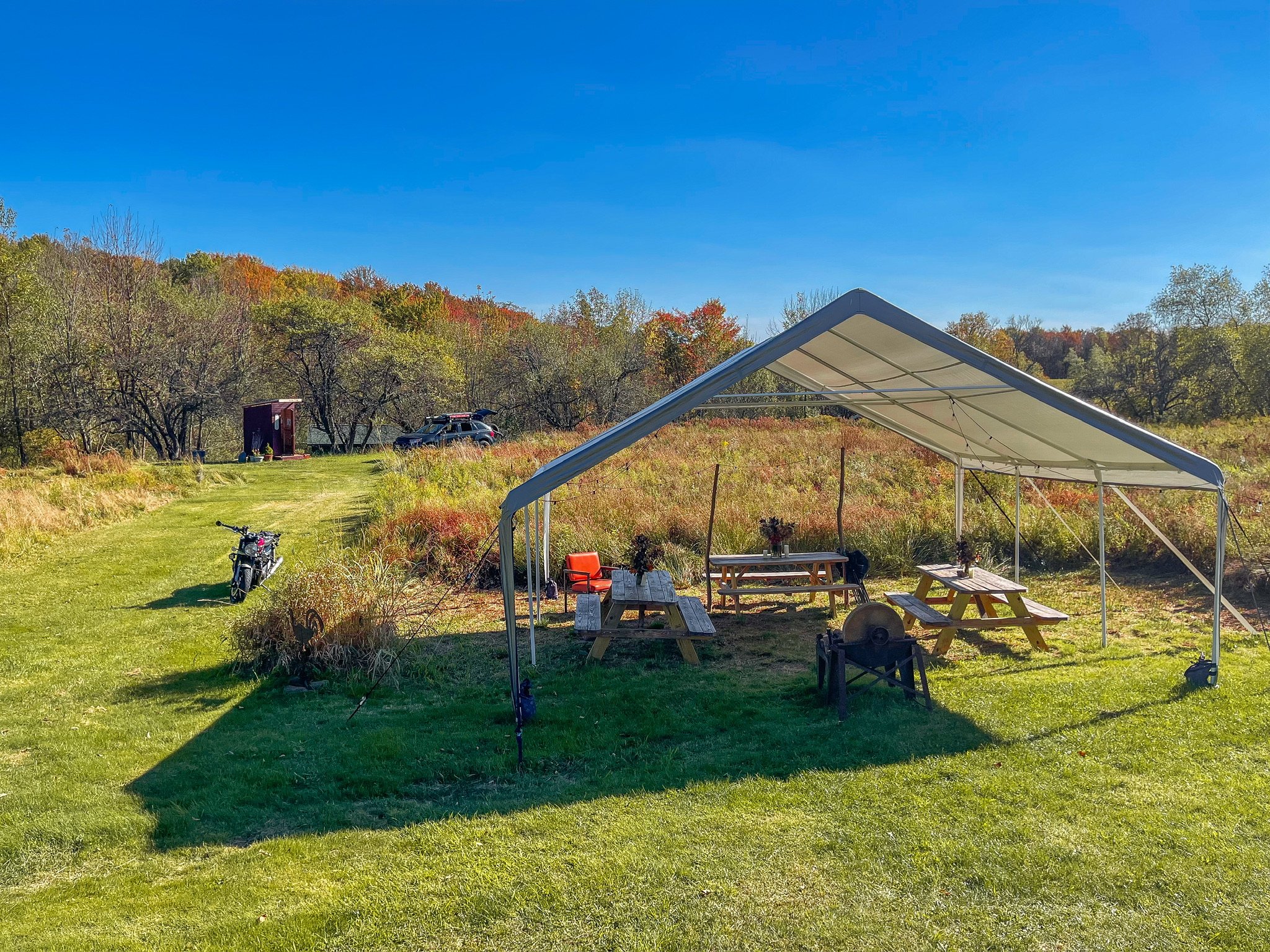view of the entire event area with fall folioage and motorcycle and car camping Autumn GLow Catskills Camping Weekend at Basecamp Brooklyn Estates.JPG