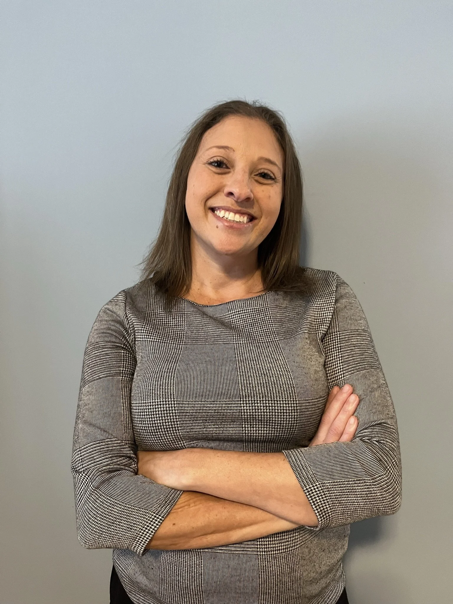 Brandi Van, professional psychic and mentor, smiling warmly at her desk, creating a welcoming and approachable environment for clients.