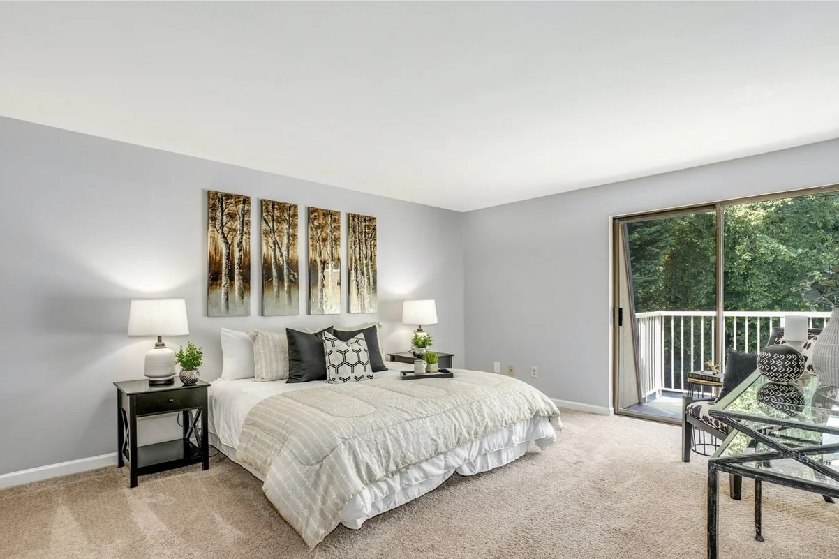 Primary bedroom with sliding door leading to deck that views the peaceful greenbelt and sparkling pool