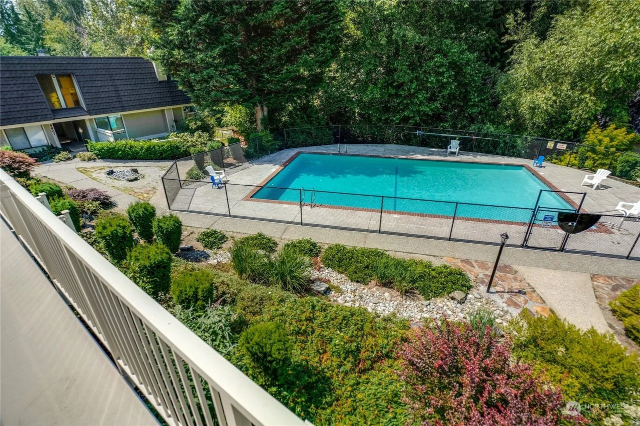View of pristine pool and greenbelt from private balcony
