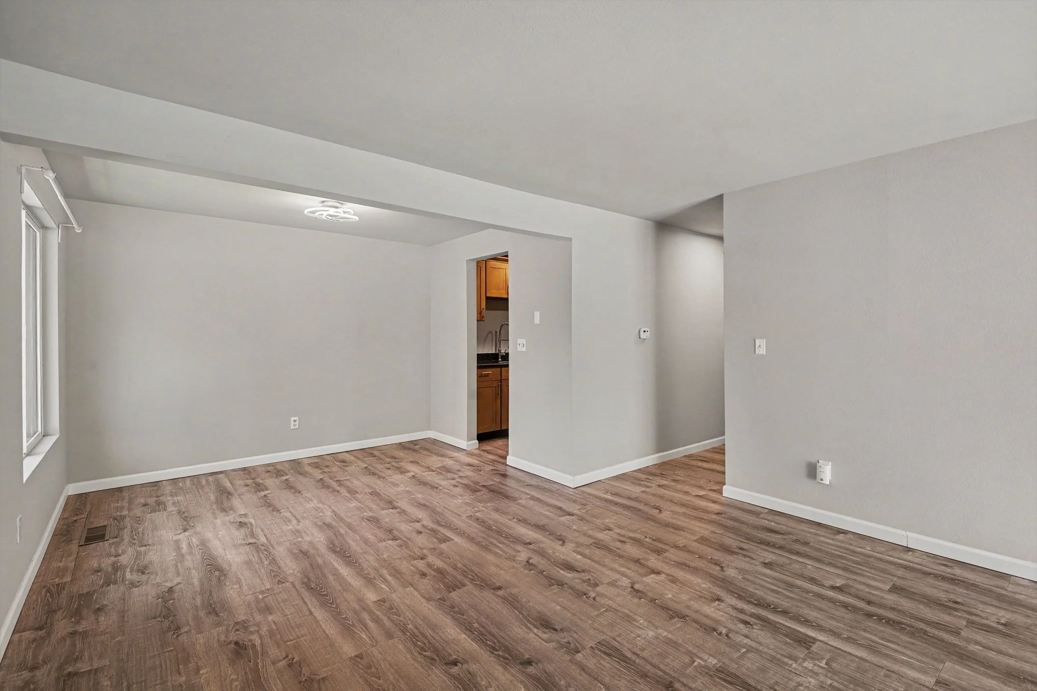 Living room looking towards dining area showing durable 100% waterproof and scratch-resistant LVP flooring