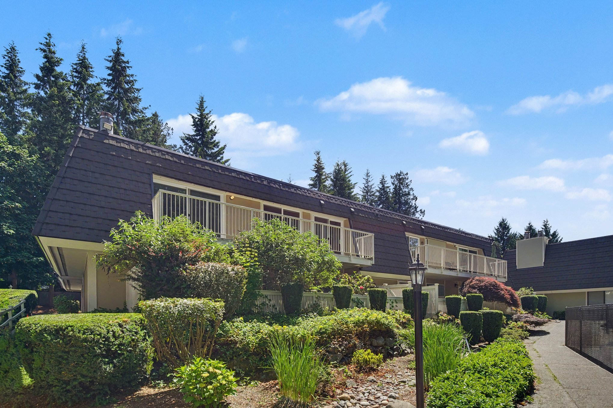Private balcony and pathway to pool, greenbelt, sport court and picnic area with views of Juanita Creek