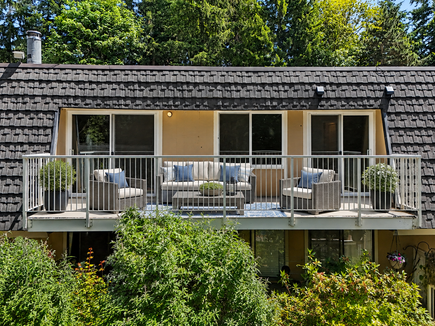Private balcony virtually staged with sitting area, including couch two chairs, and table