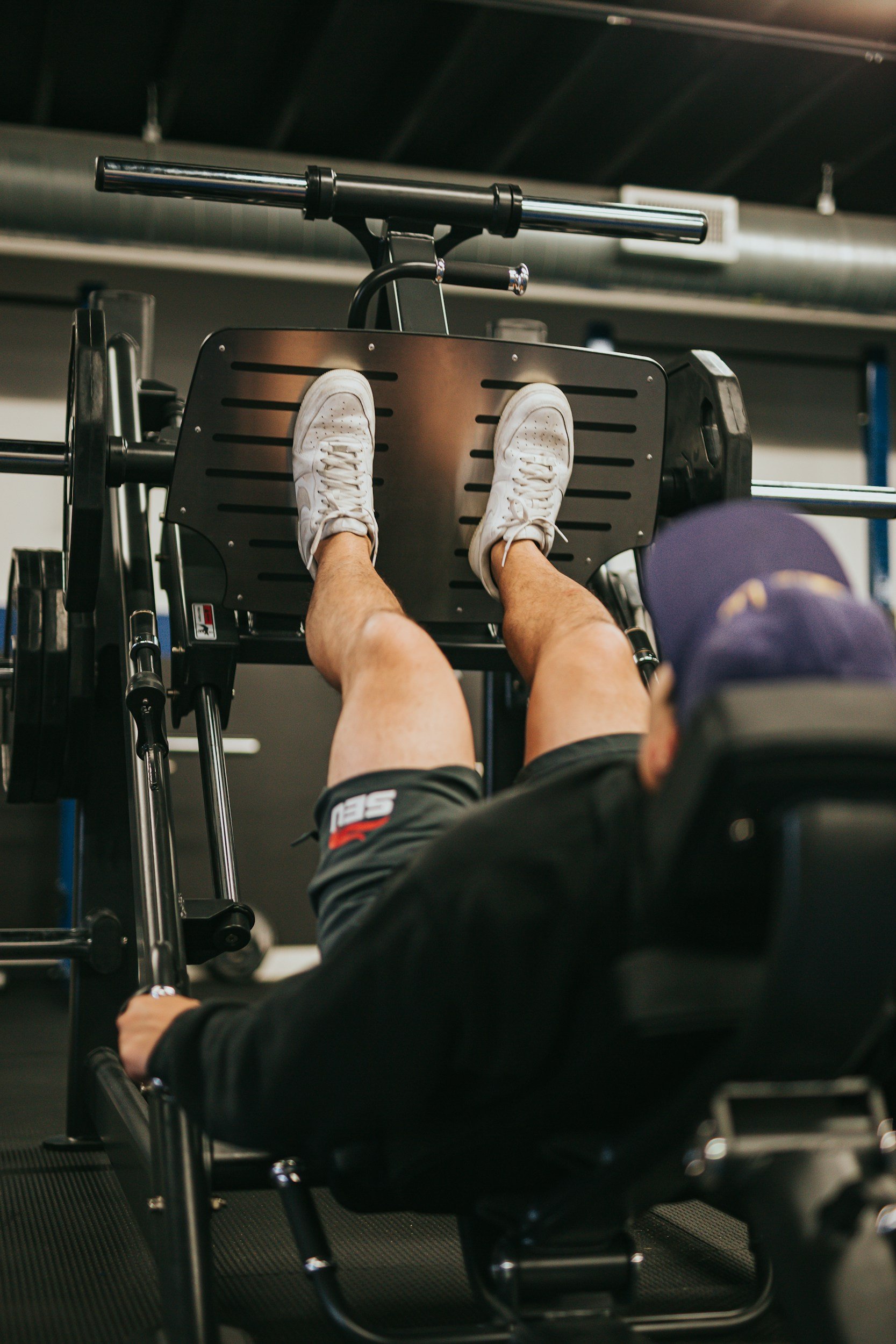 Man performing a leg press exercise to build lower body strength during rehabilitation.