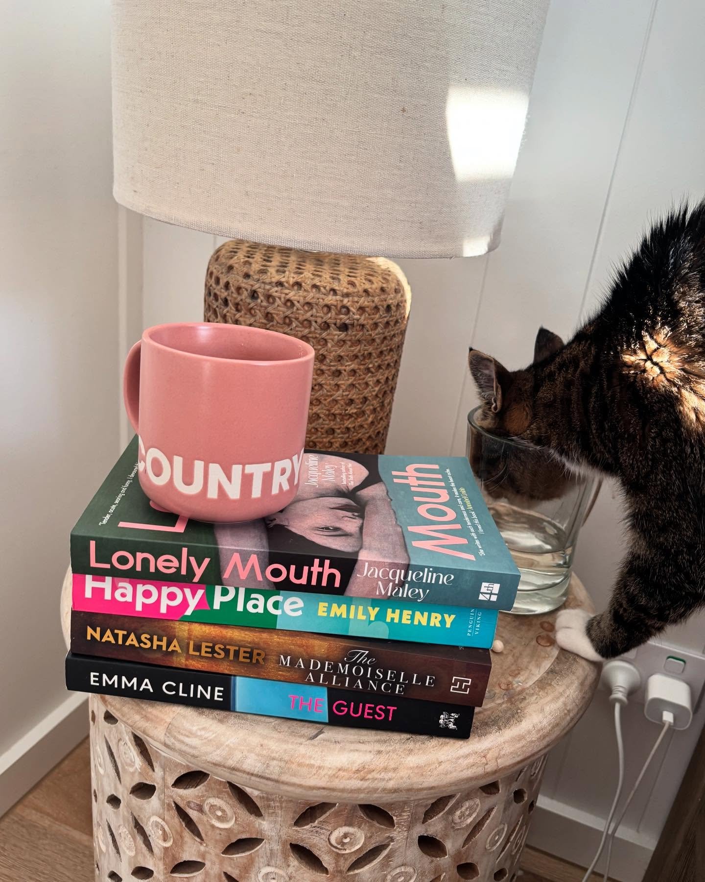 Sunday morning. Bed, books and a cat drinking out of my water glass.