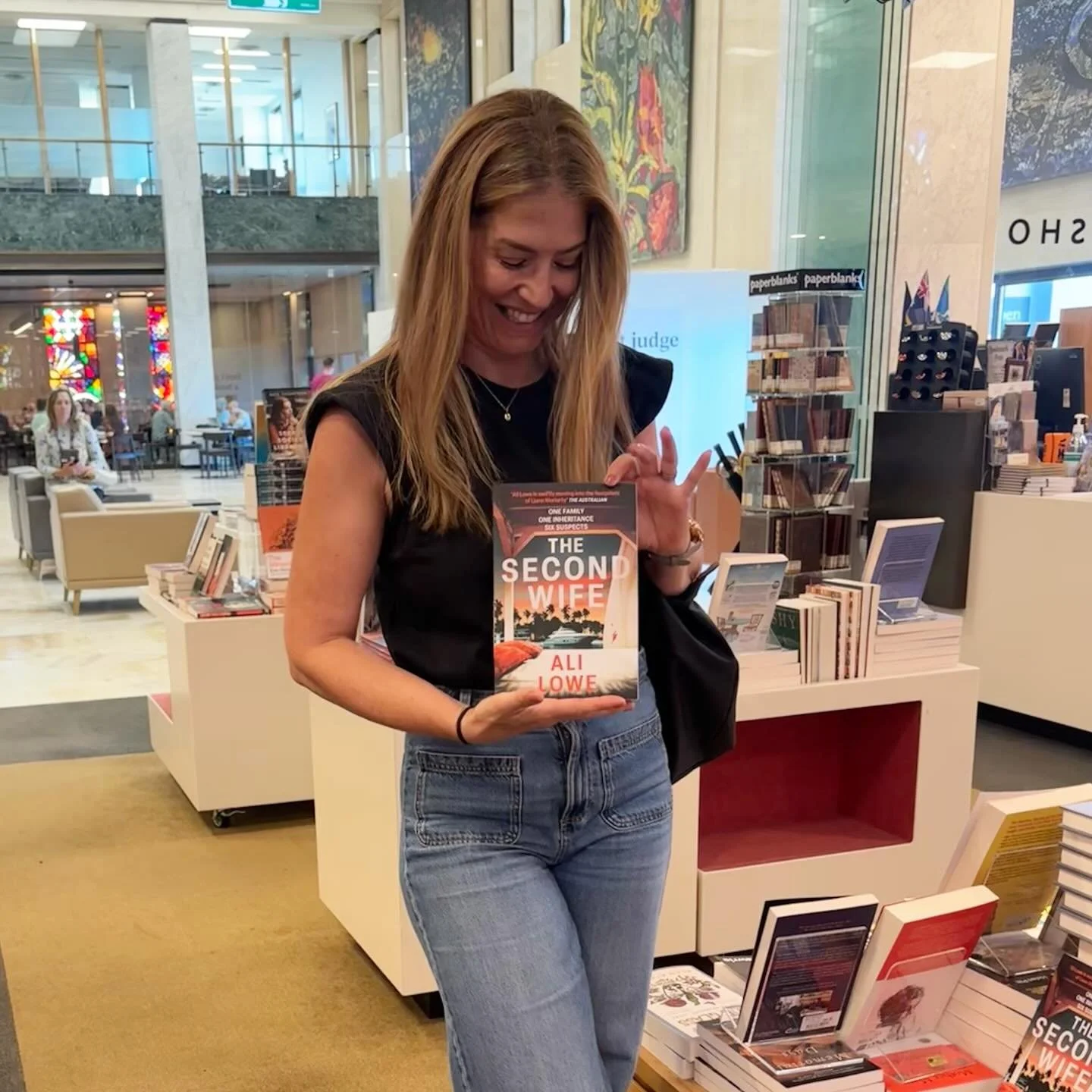 Spotted The Second Wife in the shop in the National Library of Australia in Canberra this morning. I scrawled on a few copies, and a member of staff stuck a very cute &lsquo;signed copy&rsquo; sticker on each one. The sticker has a drawing of the lib
