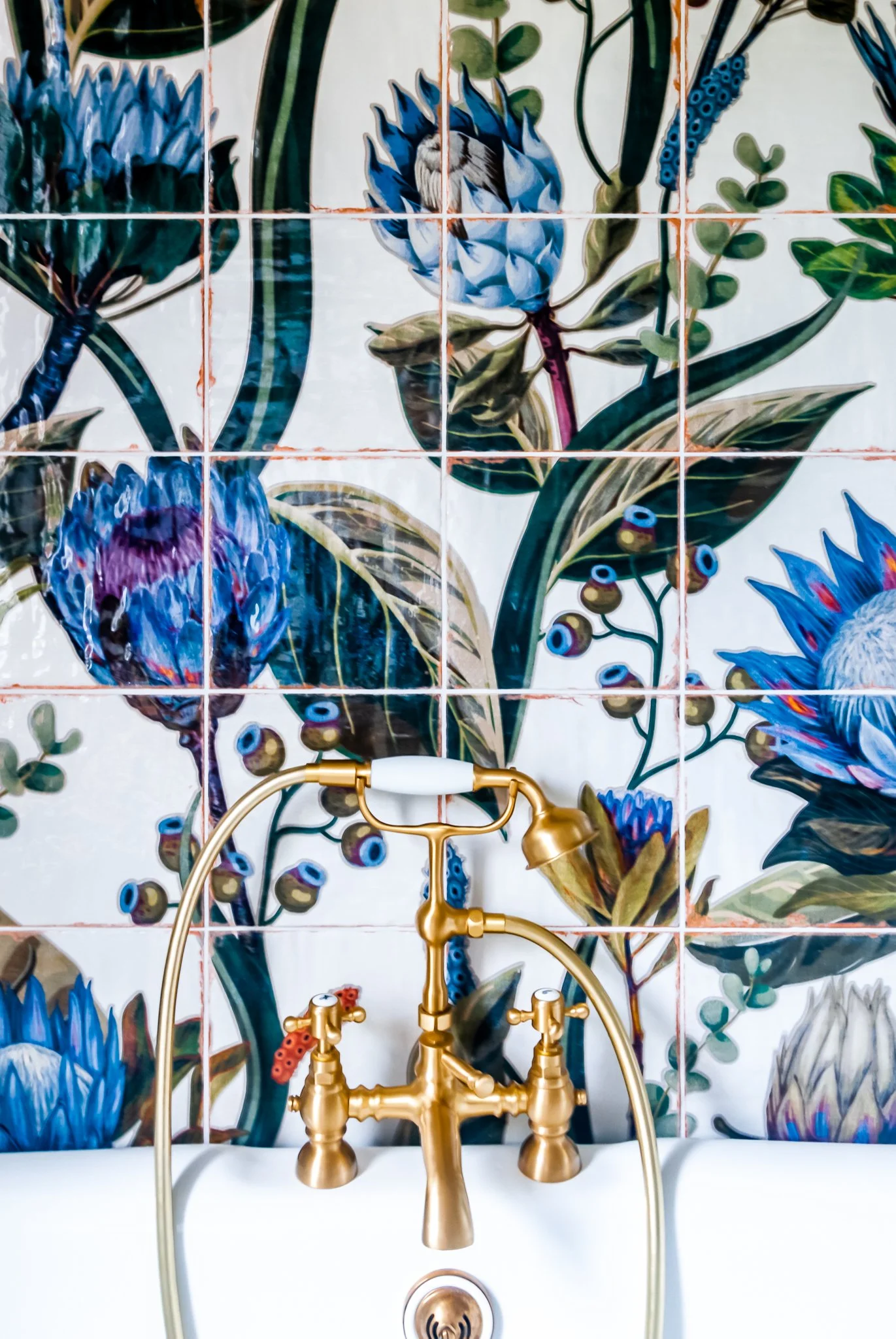 Family bathroom in Brockley with feature floral mural tiles, brass taps and freestanding bath
