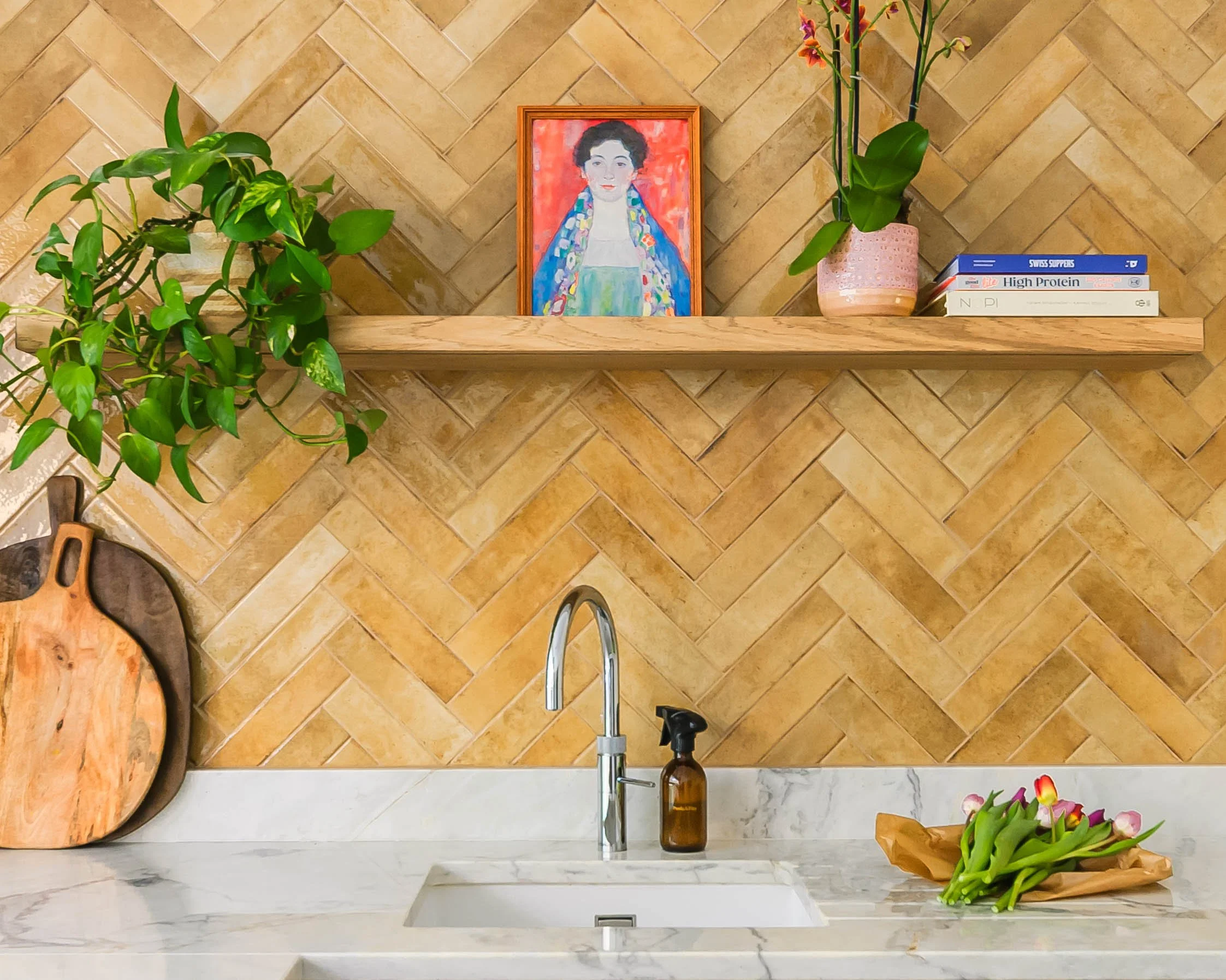 Bespoke kitchen in Forest Hill with herringbone tile splashback, open shelf, artwork, plants and warm personal details.