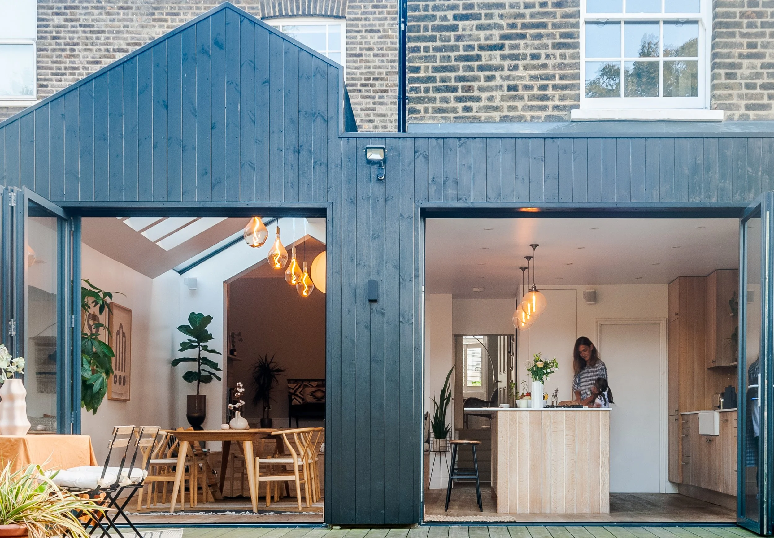 Kitchen and dining side return rear extension in Brockley, South East London with dark timber cladding and large glazed openings