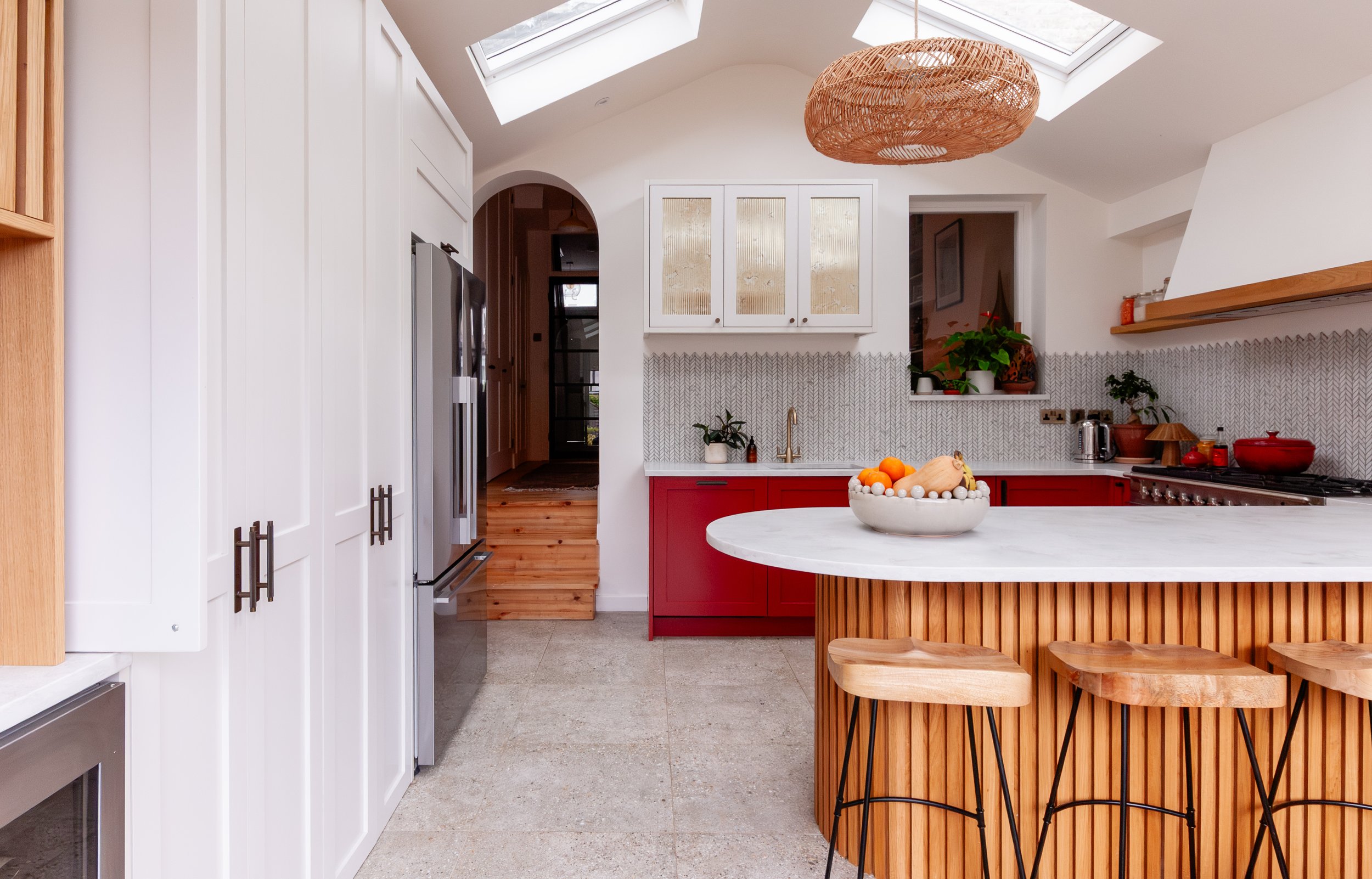 Bespoke red and oak kitchen extension in Forest Hill, South East London, with vaulted ceiling, rooflights and curved peninsula seating