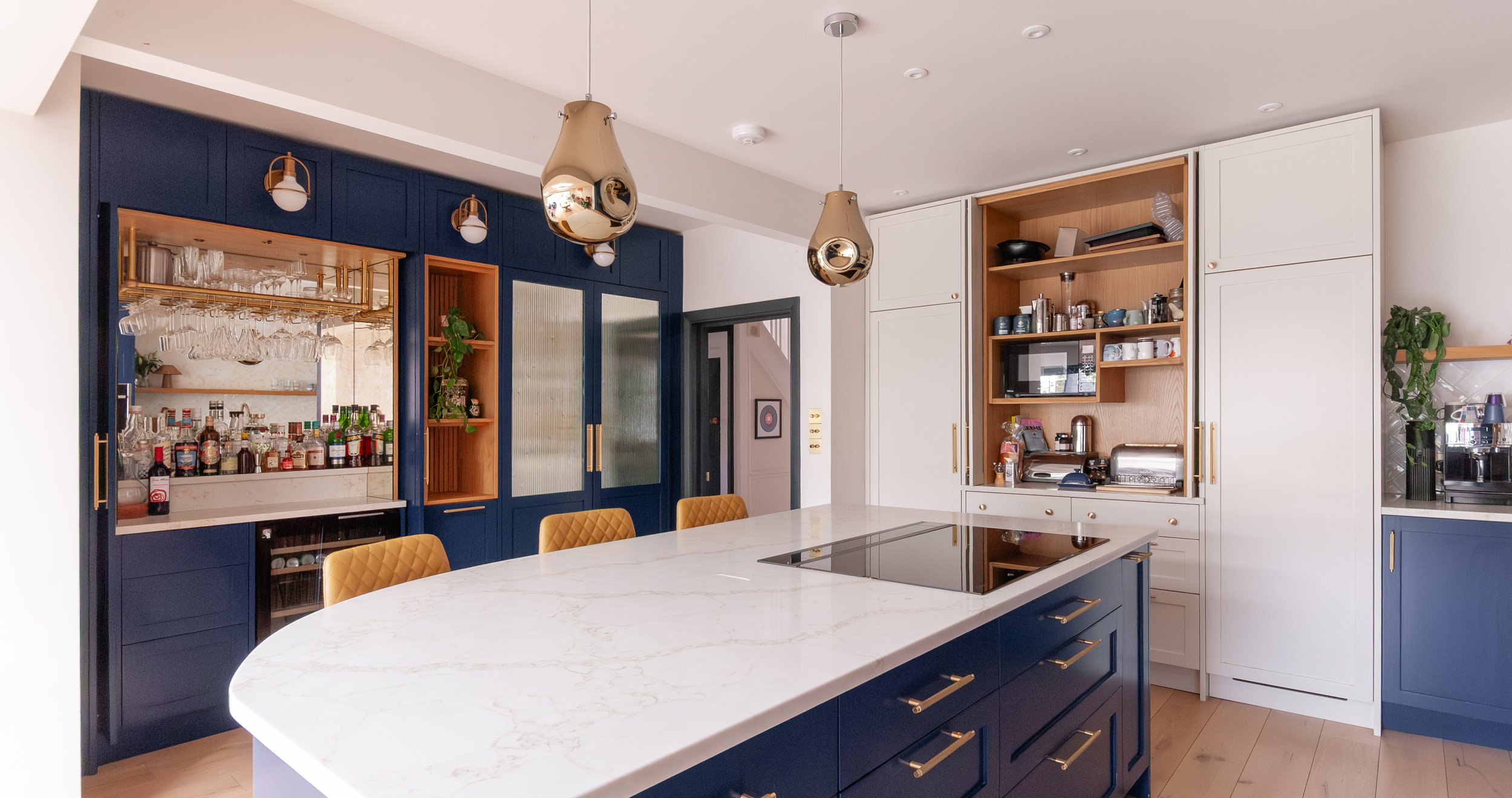 Kitchen island with induction hob, home bar and breakfast cupboard in Beckenham