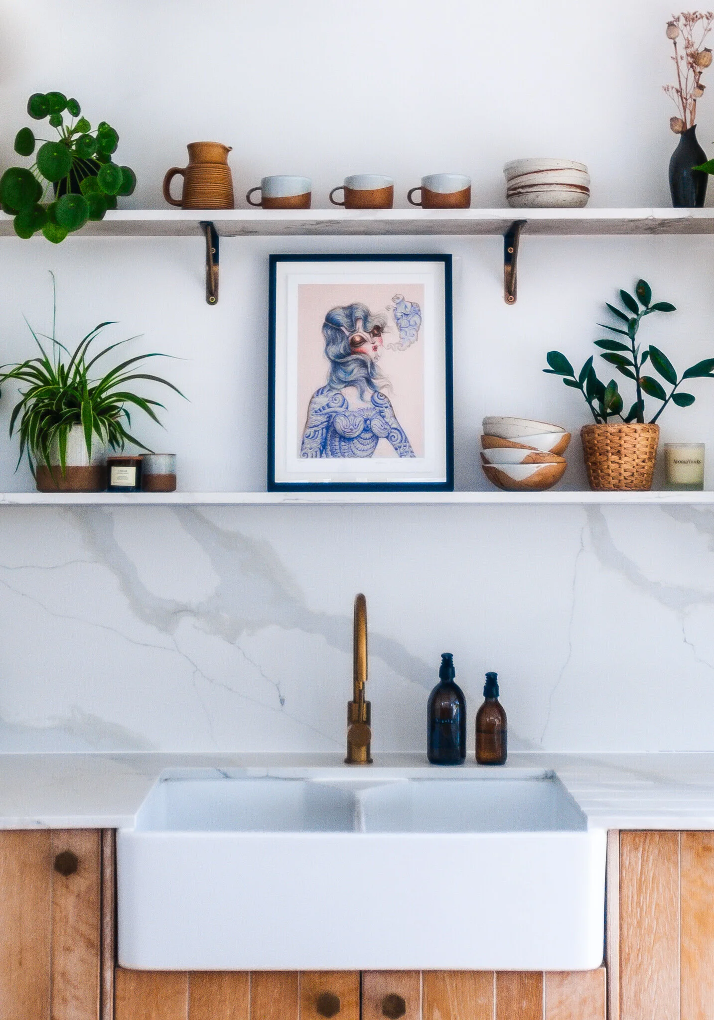 Timber kitchen in Brockley with open shelving, artwork, plants, brass tap and personal styling details.