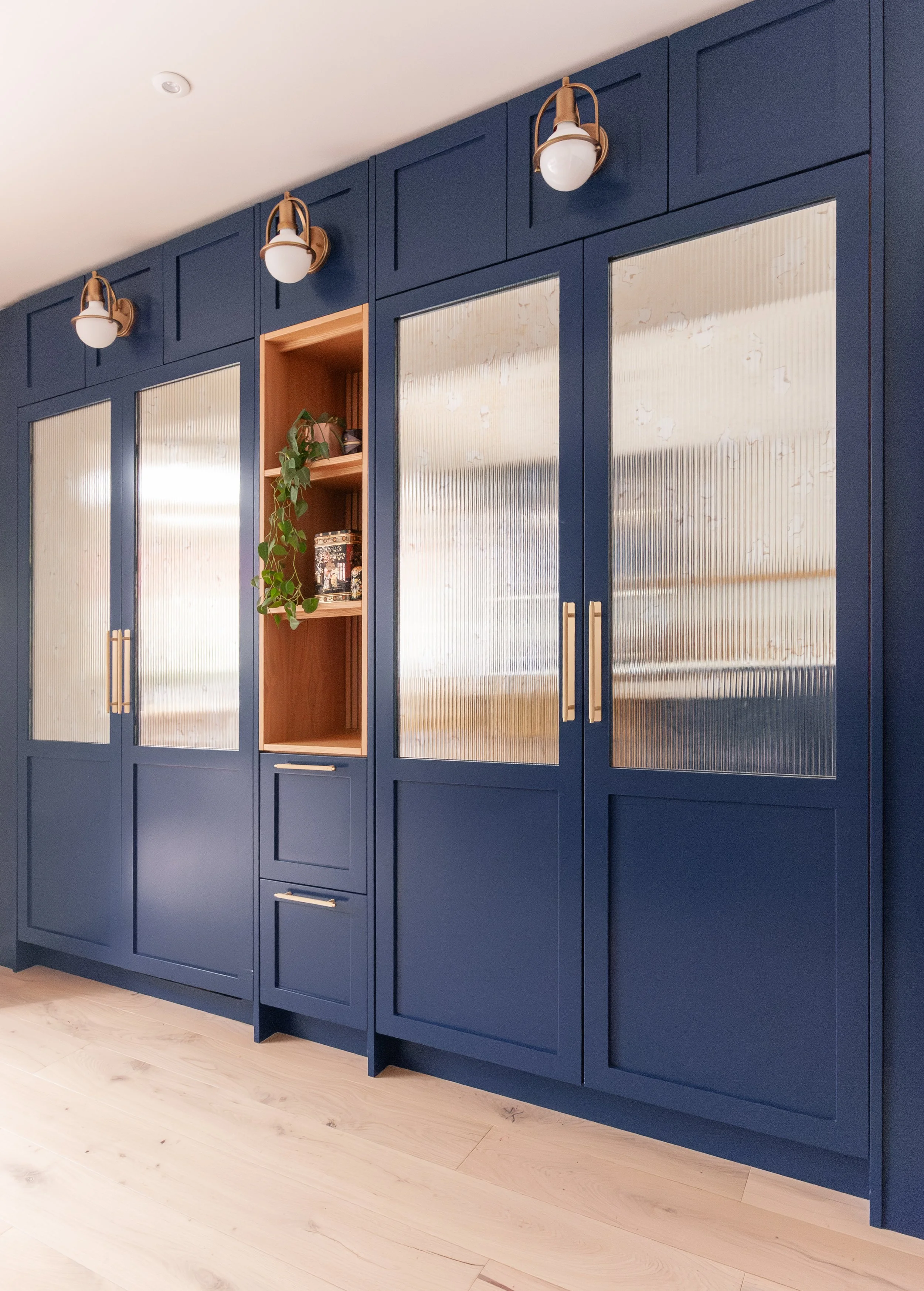 Blue glazed kitchen cabinetry with fluted glass and open timber display niche in Beckenham