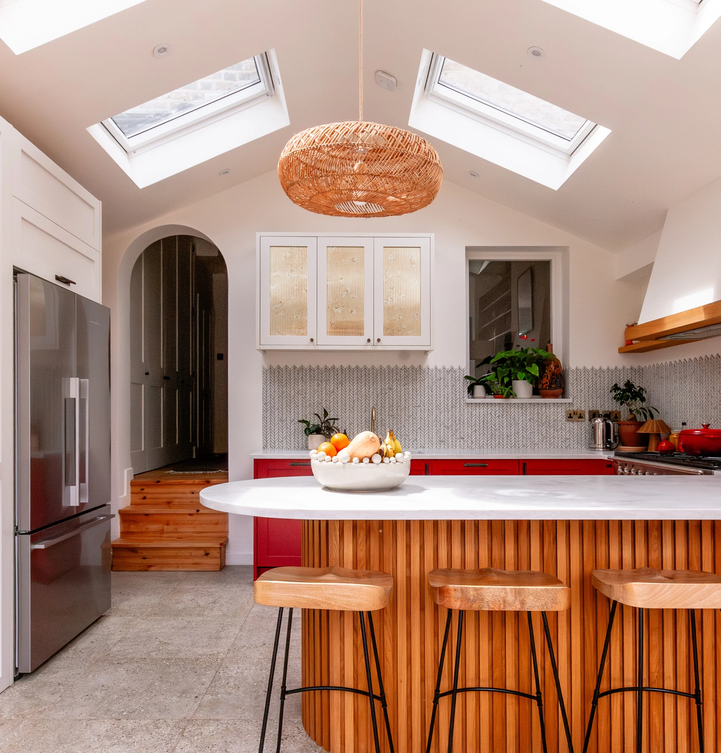 Bespoke red and oak kitchen extension in Forest Hill, South East London, with curved peninsula seating, vaulted ceiling, rooflights and reeded antique mirror glass cabinetry
