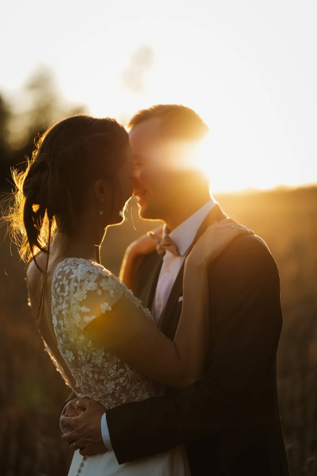 couple mariés s'enlace devant le coucher du soleil