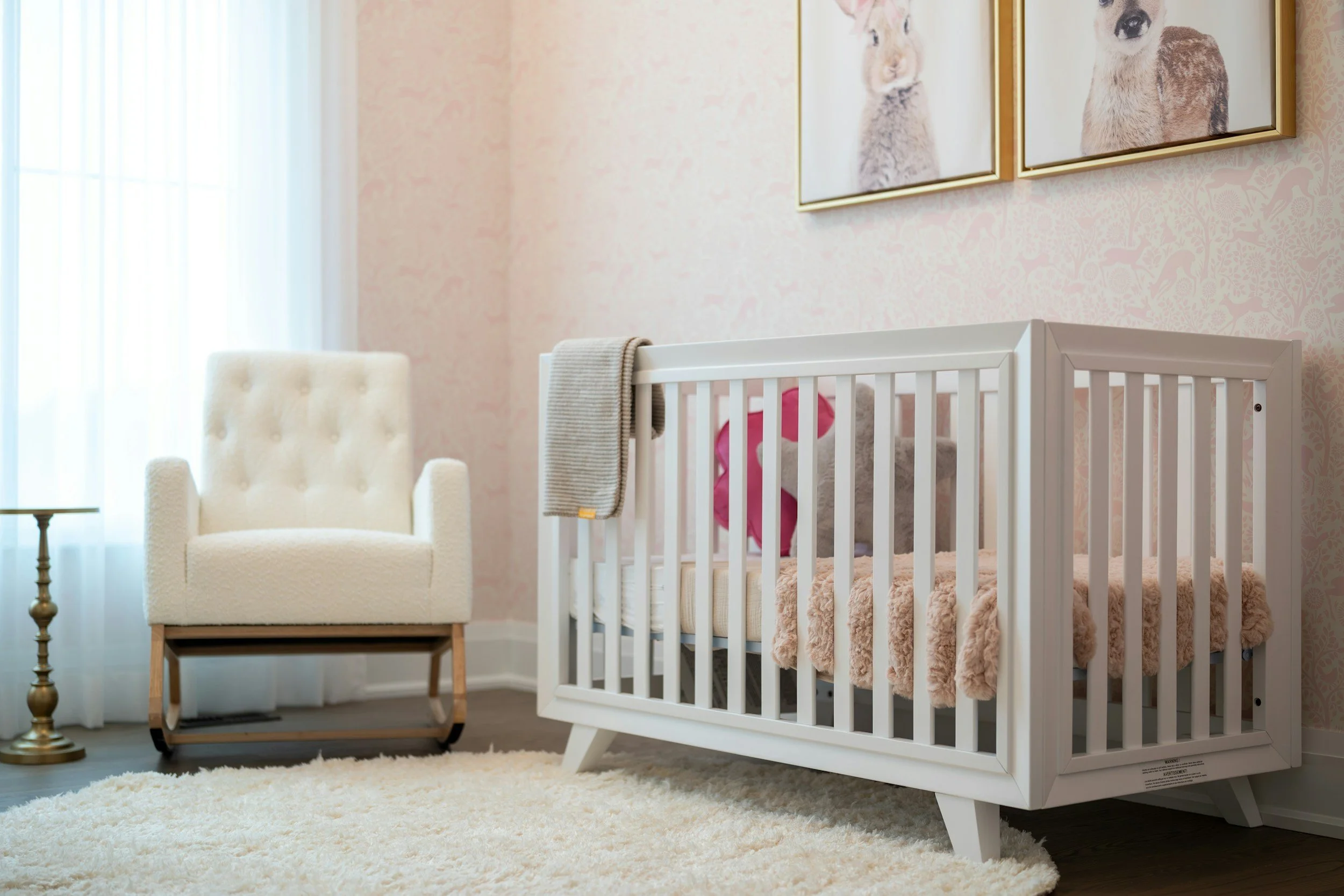 Baby sleeping in a quiet nursery while parents consider whether sound machines and white noise are helpful or harmful for sleep.