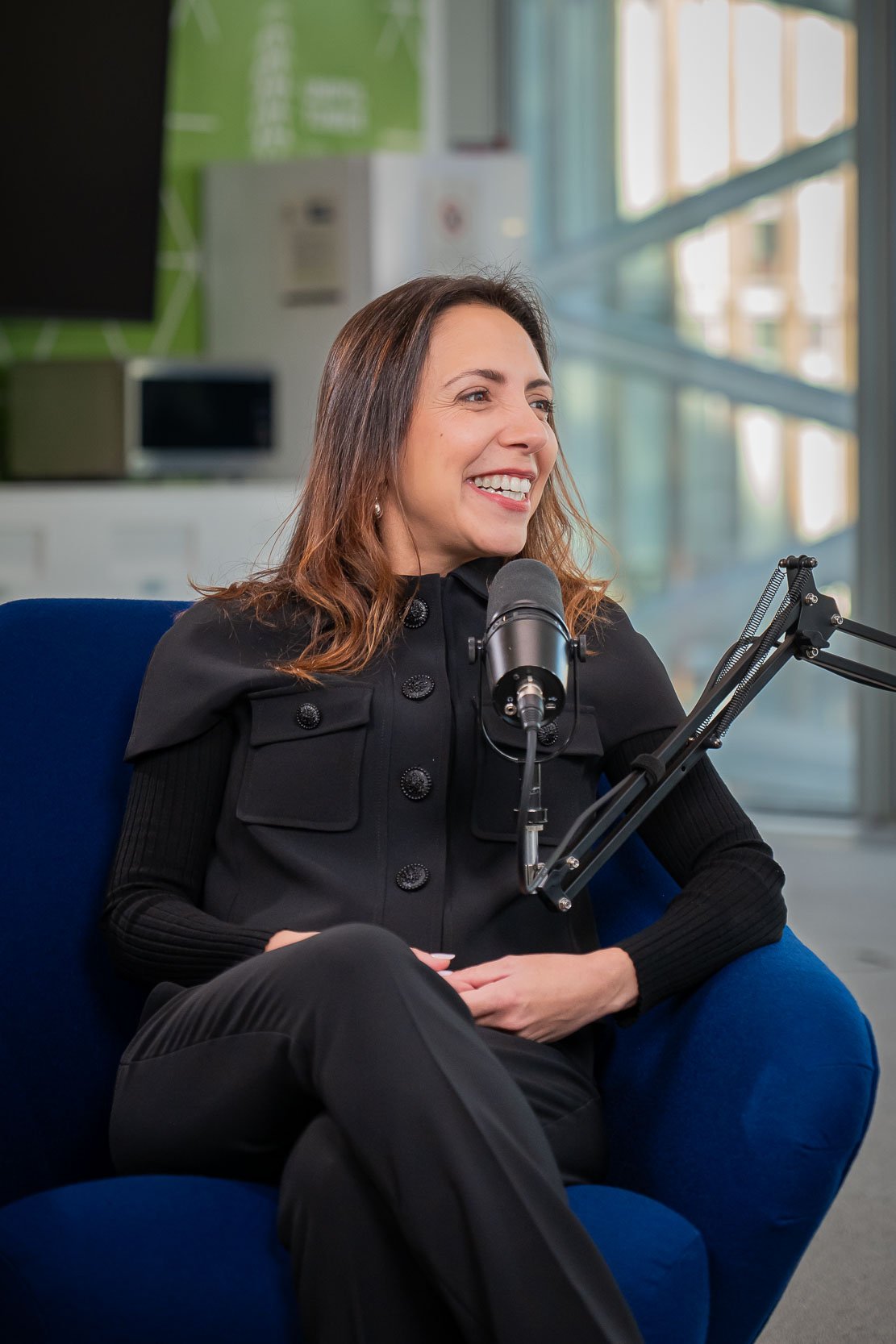Ospite sorridente durante la registrazione del podcast Unipol negli studi aziendali di Milano.
