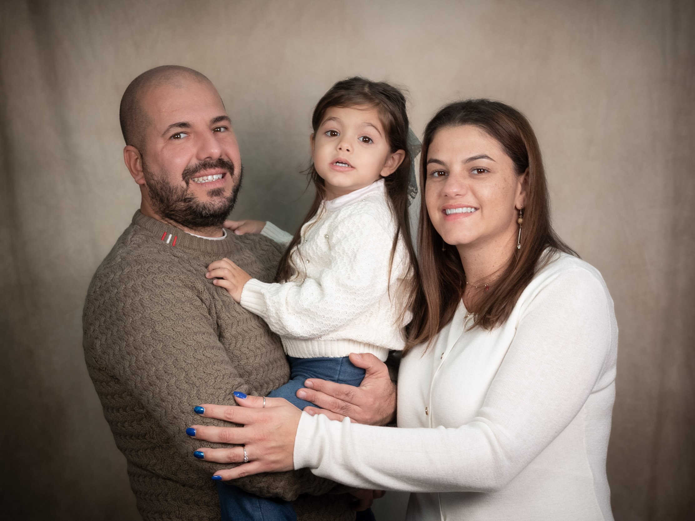 Ritratto di famiglia in studio con mamma, papà e bambina in posa elegante – servizio fotografico di famiglia a Milano Sud, Buccinasco, Corsico e Trezzano sul Naviglio.