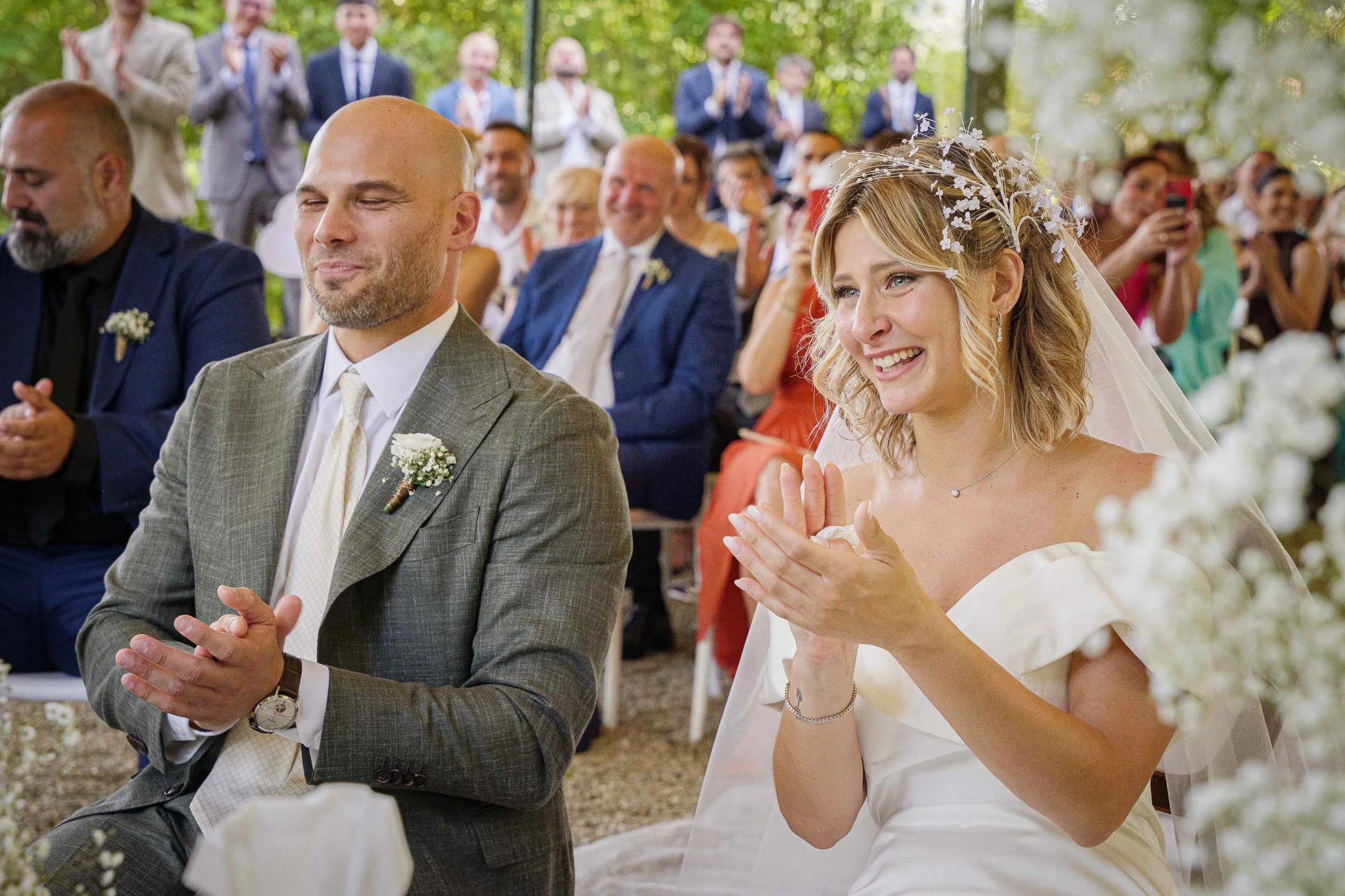 Sposi che applaudono durante la cerimonia civile a Tenuta Montezeglio Invorio, circondati dagli invitati in un’atmosfera gioiosa
