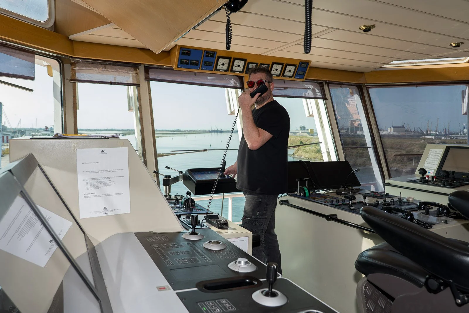 Un membro dell’equipaggio usa una cornetta per comunicare dalla plancia dell’Asso Ventiquattro, tra le console di comando.