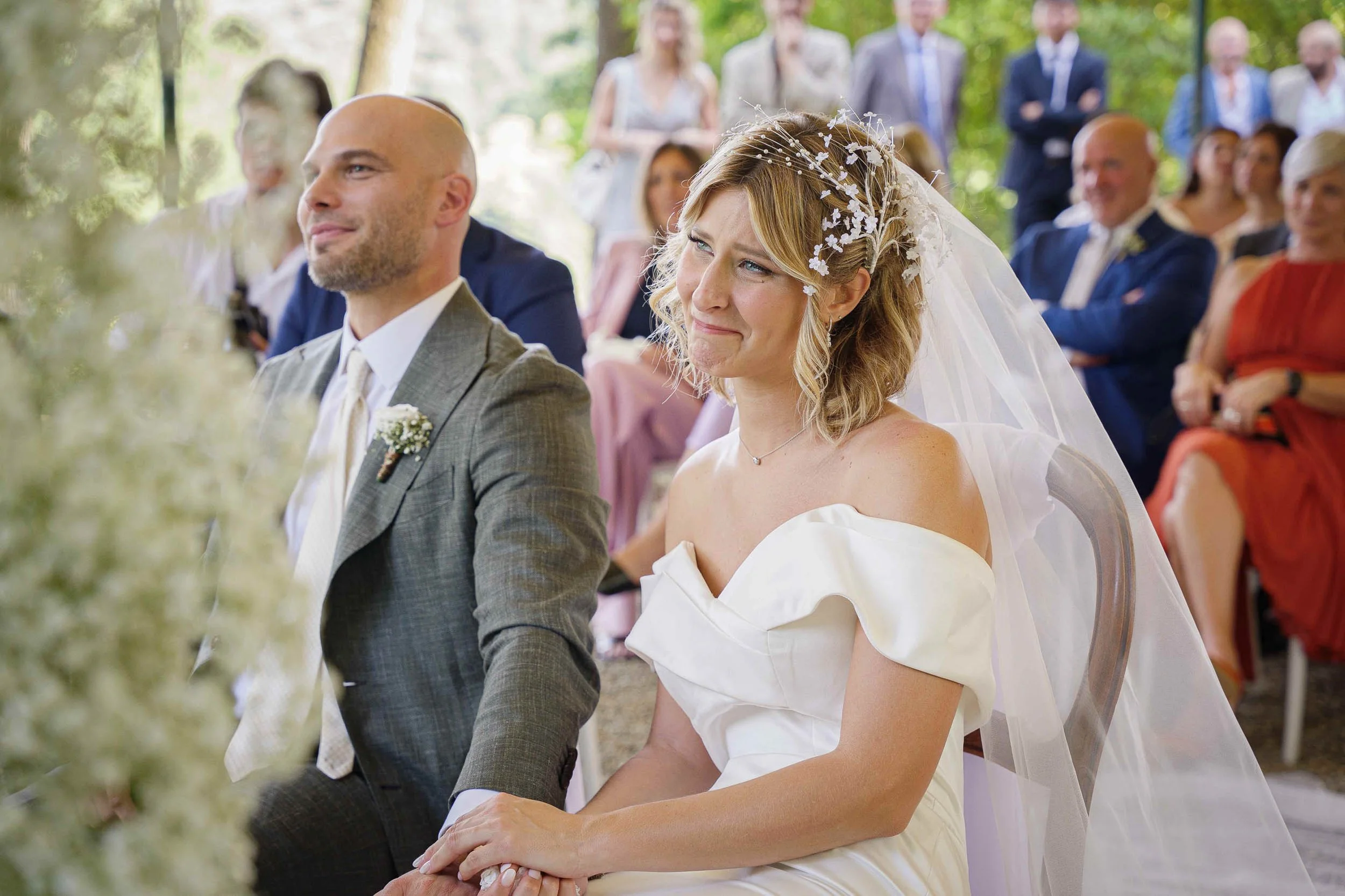 Sposa commossa durante lo scambio delle promesse al matrimonio a Tenuta Montezeglio Invorio, con lo sposo accanto e gli invitati sullo sfondo