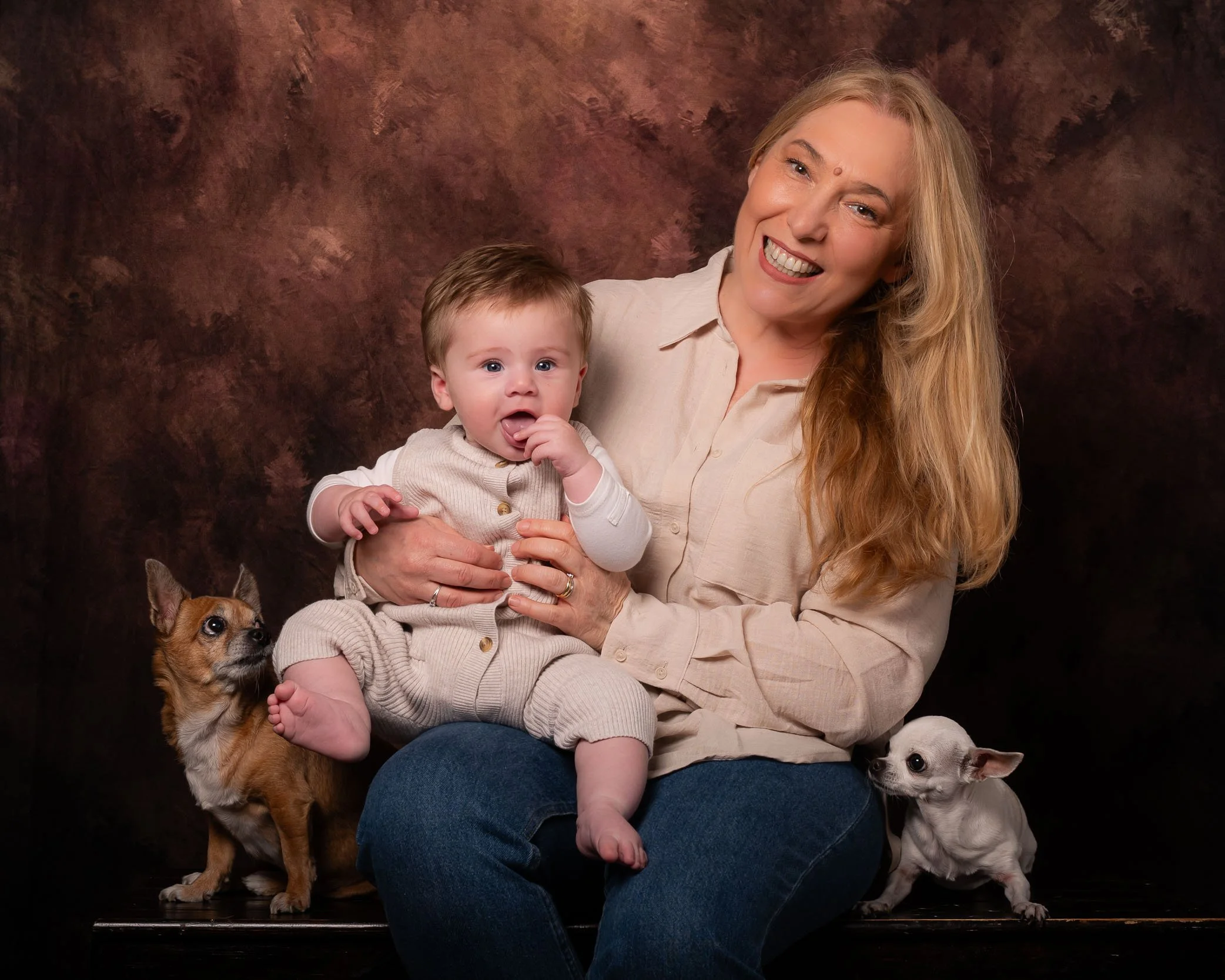 Ritratto di nonna e nipote in studio con due cani su sfondo artistico – servizio fotografico di famiglia a Buccinasco, Milano Sud.
